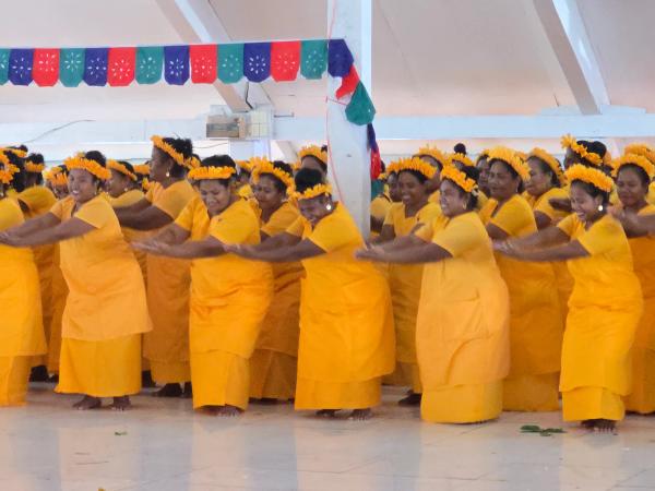 A group of women in a yellow uniform dancing together
