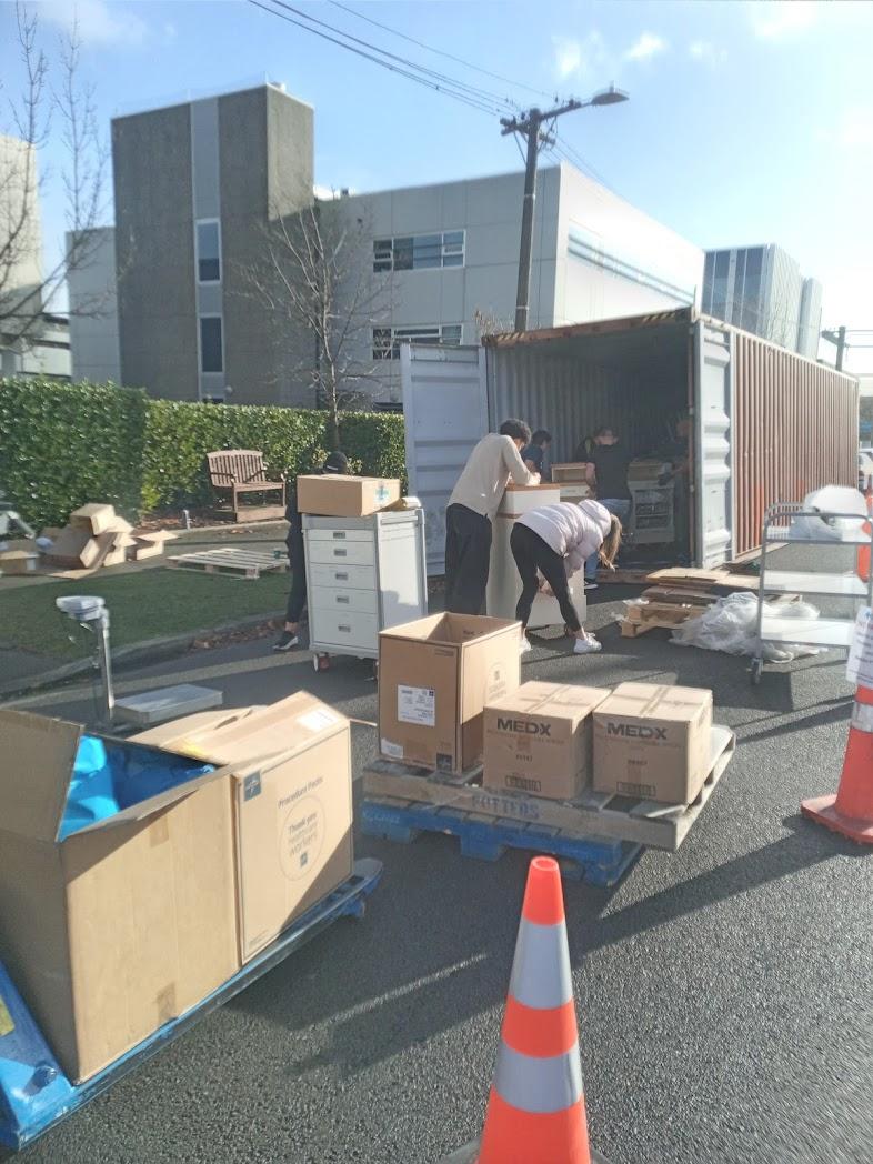 People loading boxes into a shipping container People loading boxes into a shipping container