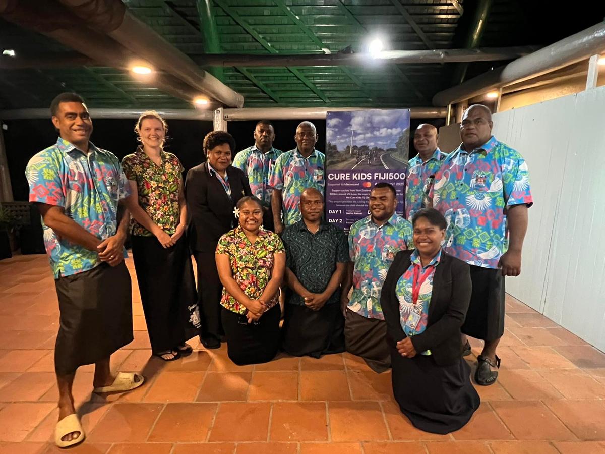 A group of people standing around a banner and smiling for the camera