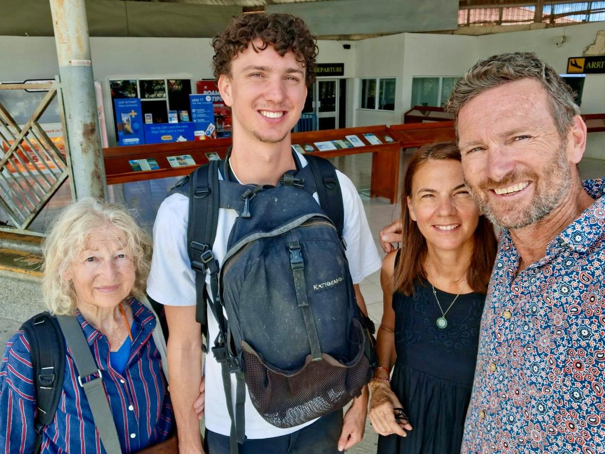Four people smile for a selfie. Four people smile for a selfie.