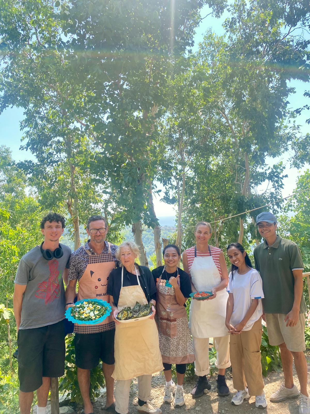 A group of people holding food after a cooking class. A group of people holding food after a cooking class.