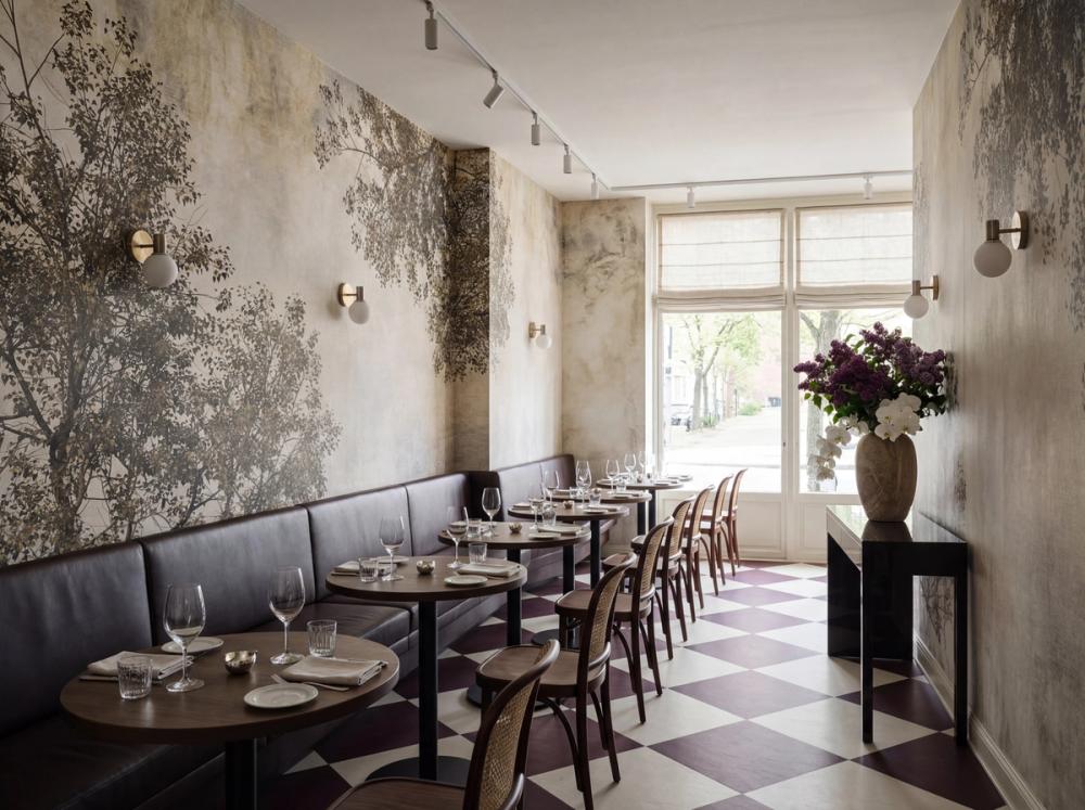 an interior photo of a french bistro with a tree crown themed wall mural on the wall