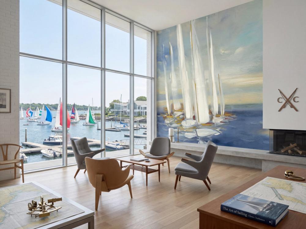 an interior photo of a scandinavian yatch club with a sail boat themed wallpaper mural on the wall