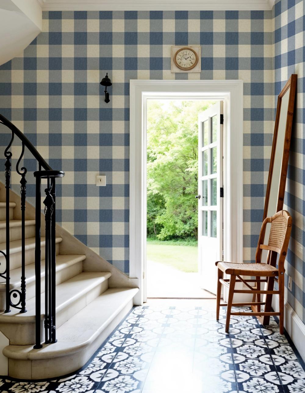 An entrance hallway with small blue and white plaid wallpaper on the walls