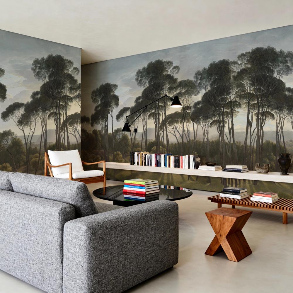 A spacius livingroom with a forest themed wallpaper mural on the walls