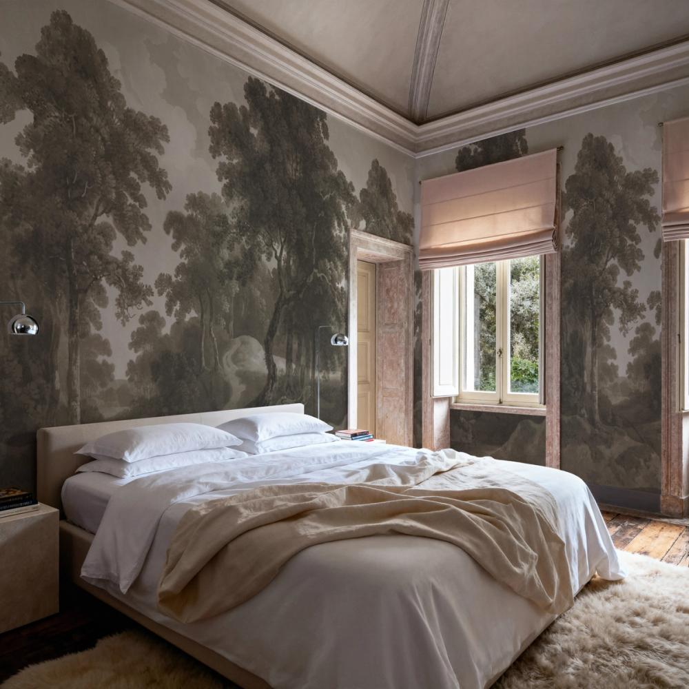 a spacious bedroom with a forest themed wallpaper on the walls