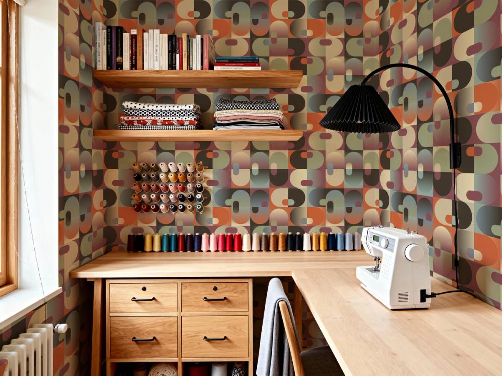 a photo of a home sewing room with craft equipment on a desc and retro wallpaper on the walls
