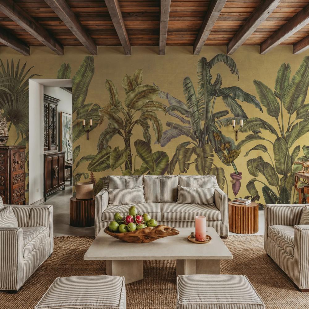 a photo of a livingroom with a tropical plants themed mural on the walls
