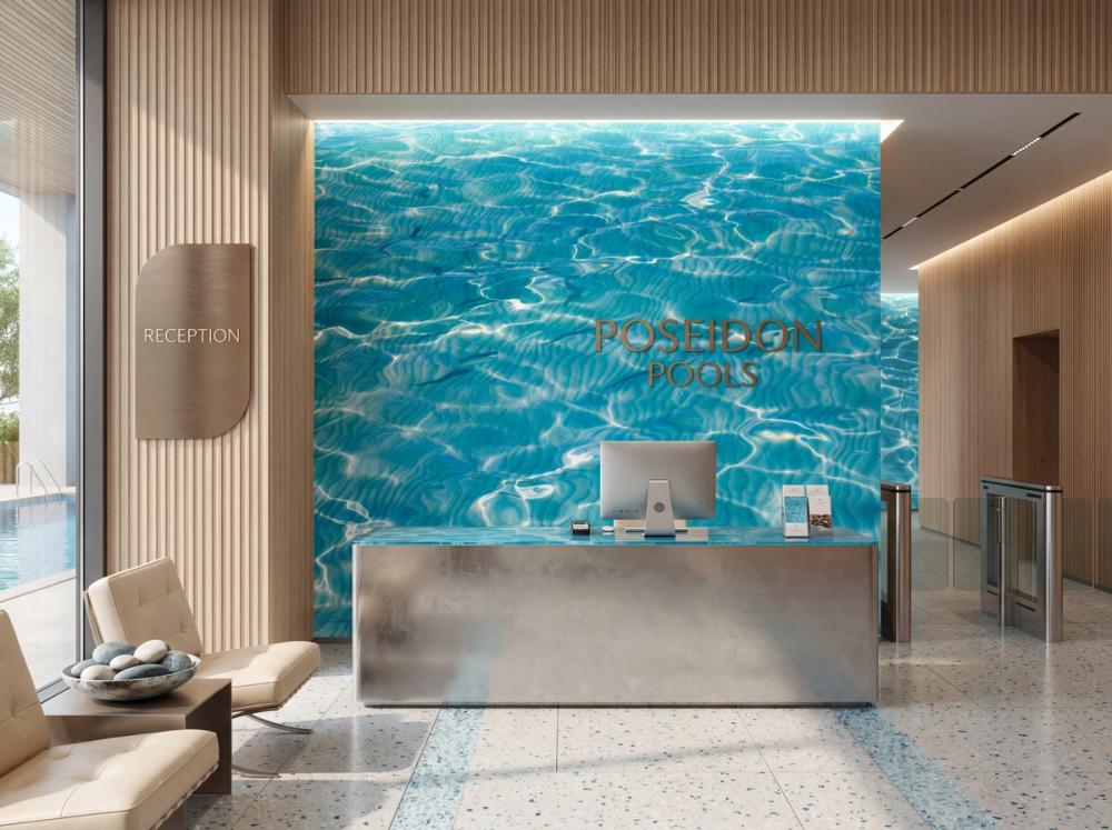 an interior photo of the reception at a swimming pool with a water themed wallpaper mural on the wall behind the desk