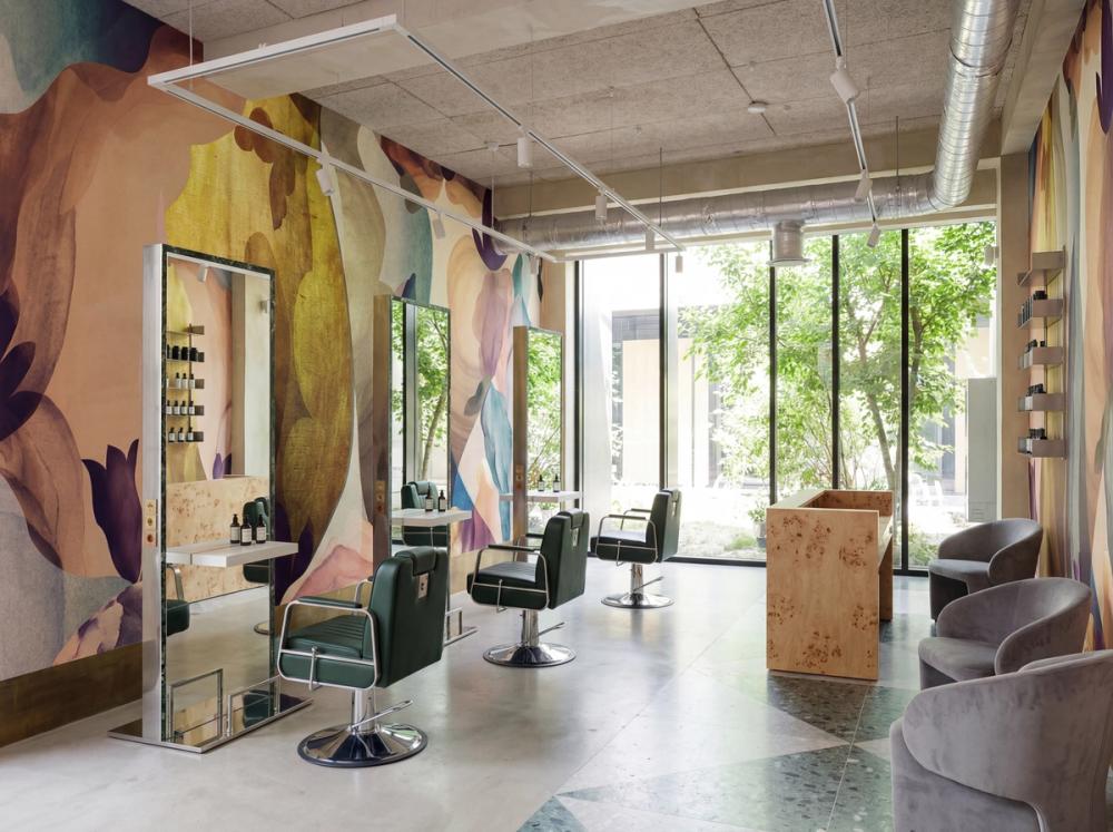an interior photo of a trendy hair salon with an abstract wall mural on the wall