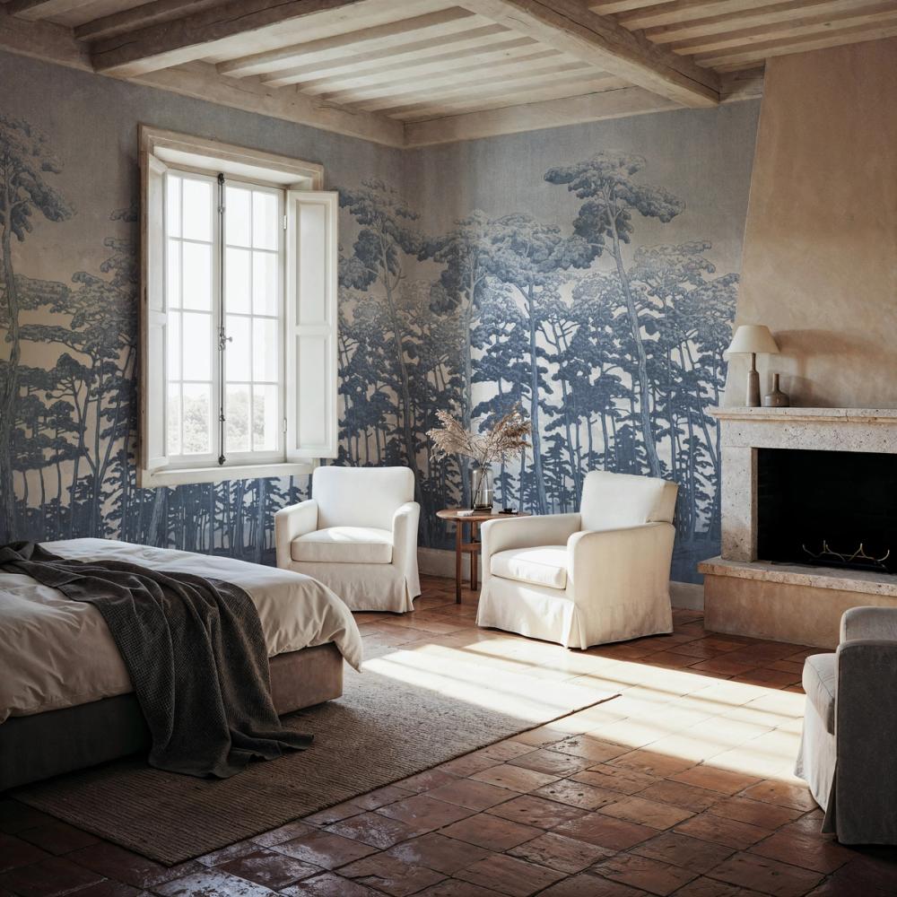 a rustic bedroom with a blue forest themed wallpaper on the walls