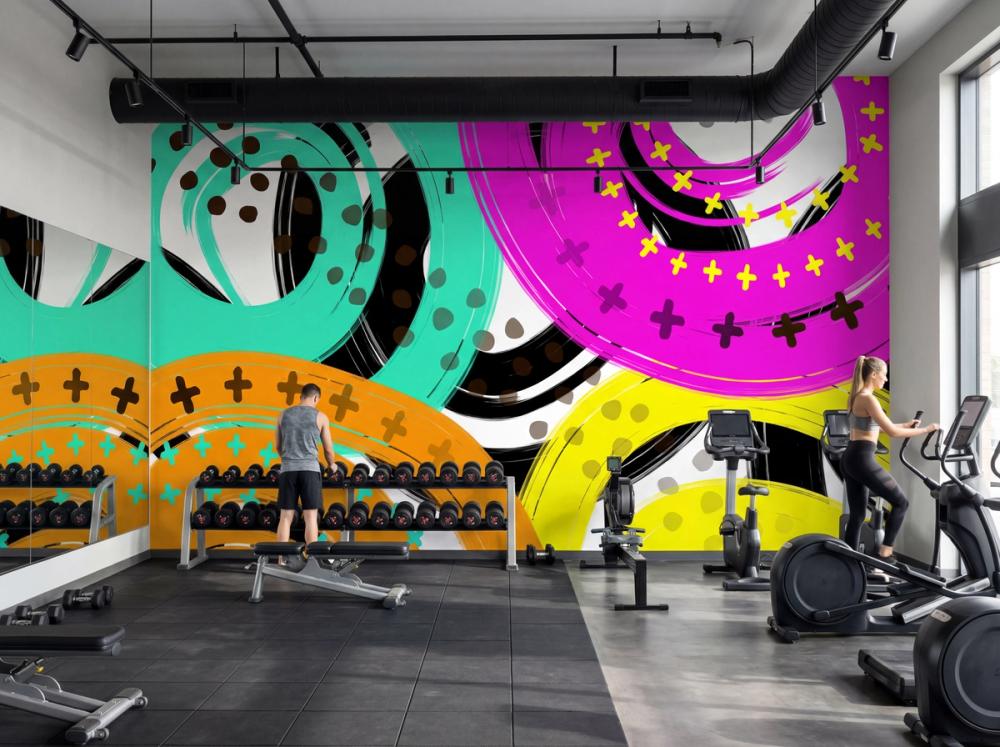 an interior photo of a large gym with a colorful abstract wallpaper mural on the main wall