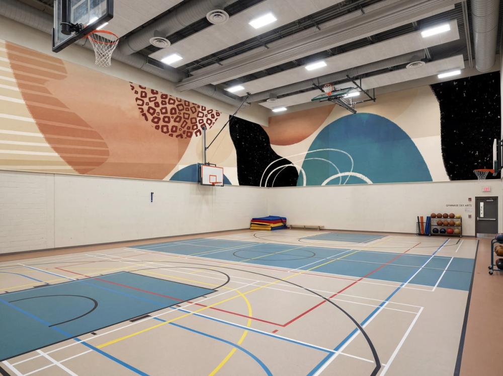 an interior photo of a gymnasium with an abstract wallpaper mural on the top part of the walls