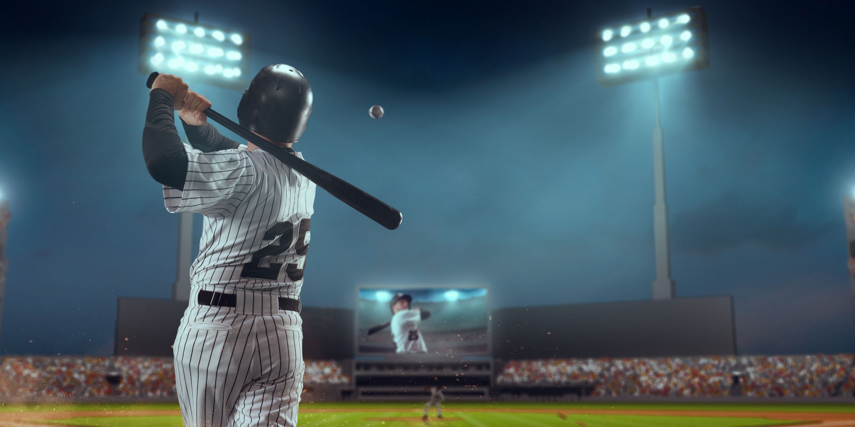 Photo from the back of a baseball pitcher ready to hit the ball