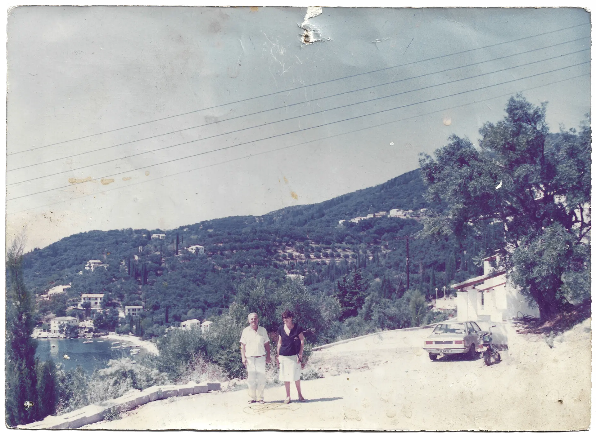 Vintage photograph of a couple standing on what today is Villa Natalia overlooking the bay of Kalami in Corfu, showcasing the early history of Villa Natalia.