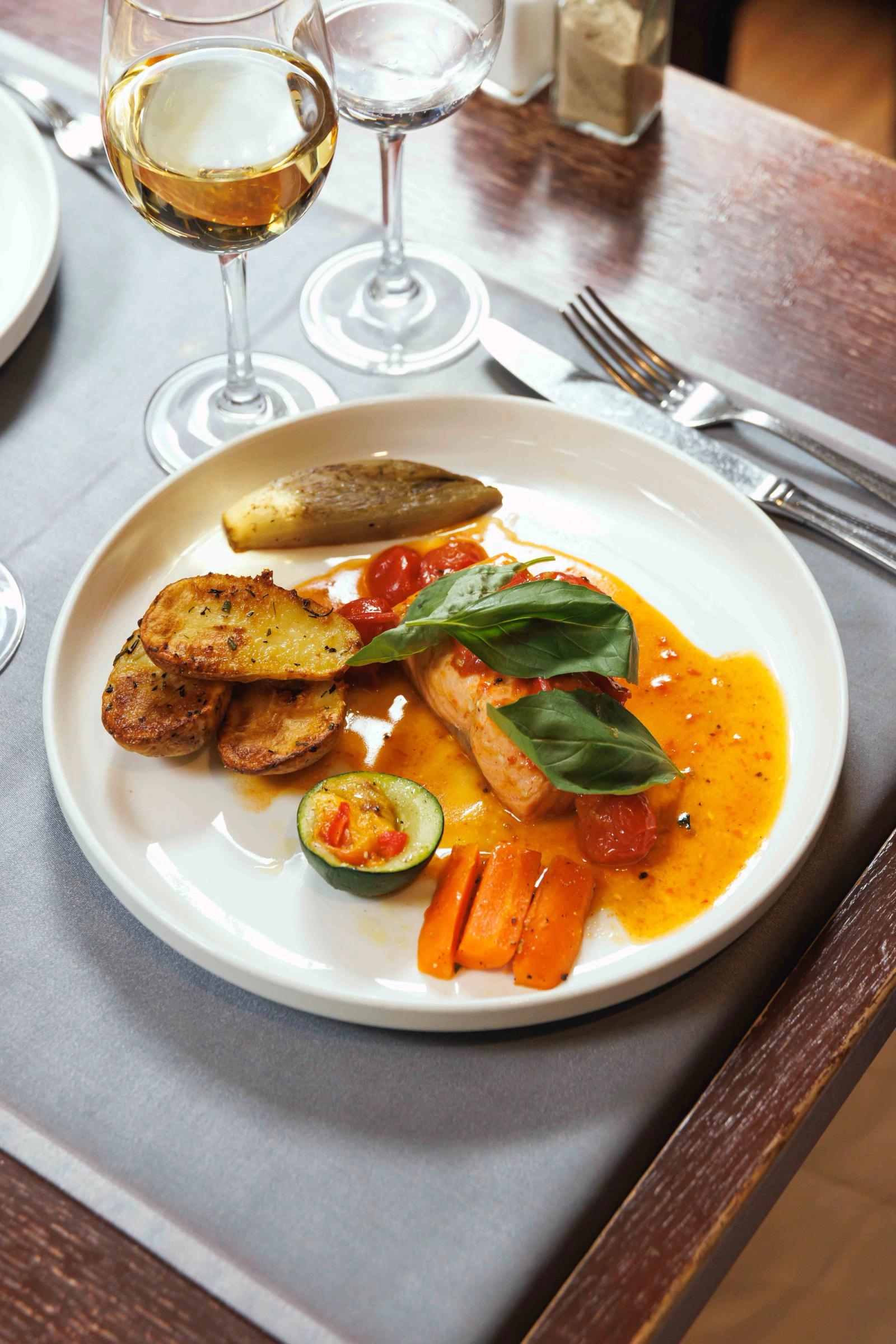 Filet de poisson en sauce safranée, accompagné de pommes de terre rôties et légumes grillés
