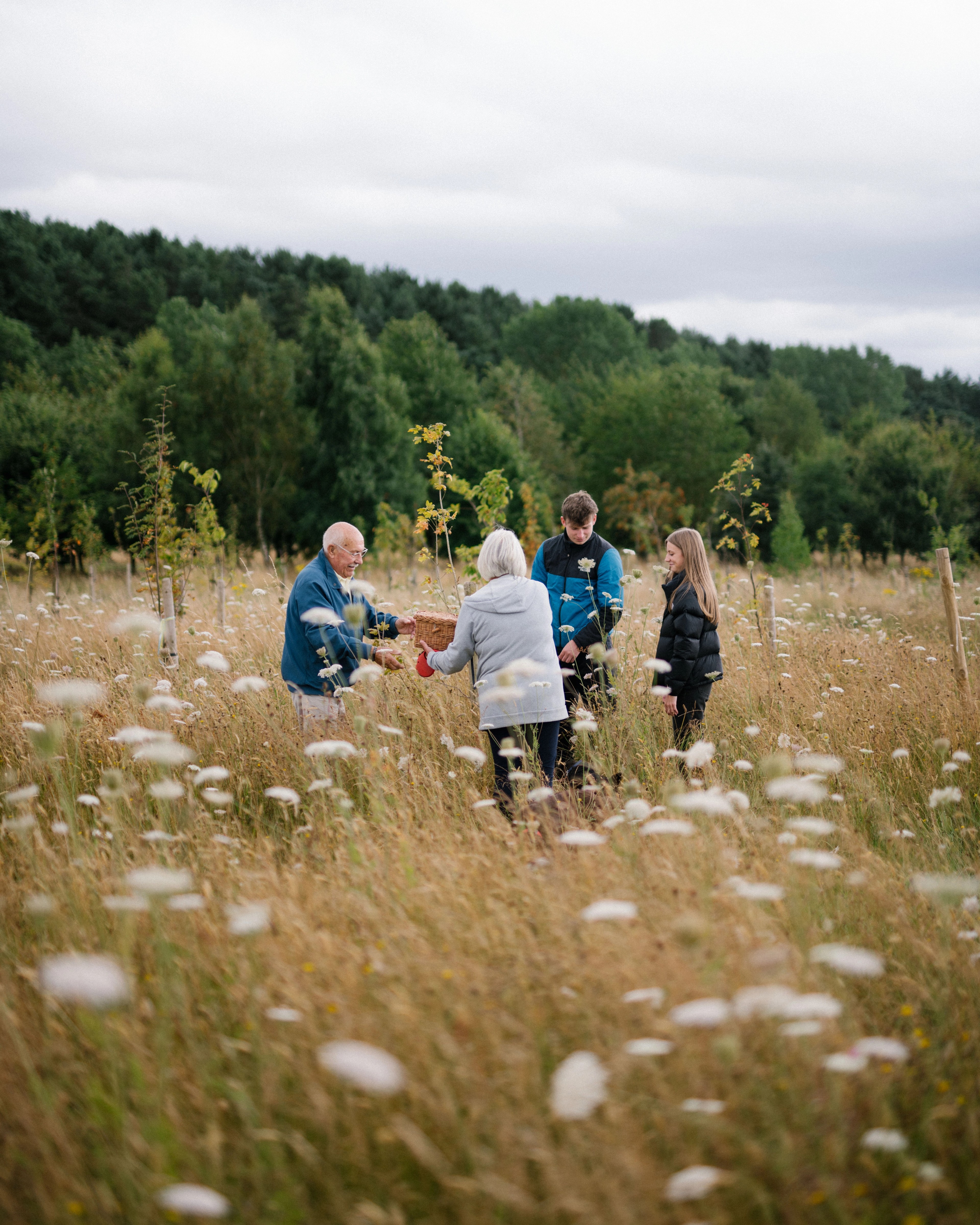 a family carrying out an interment of ashes in a meadow