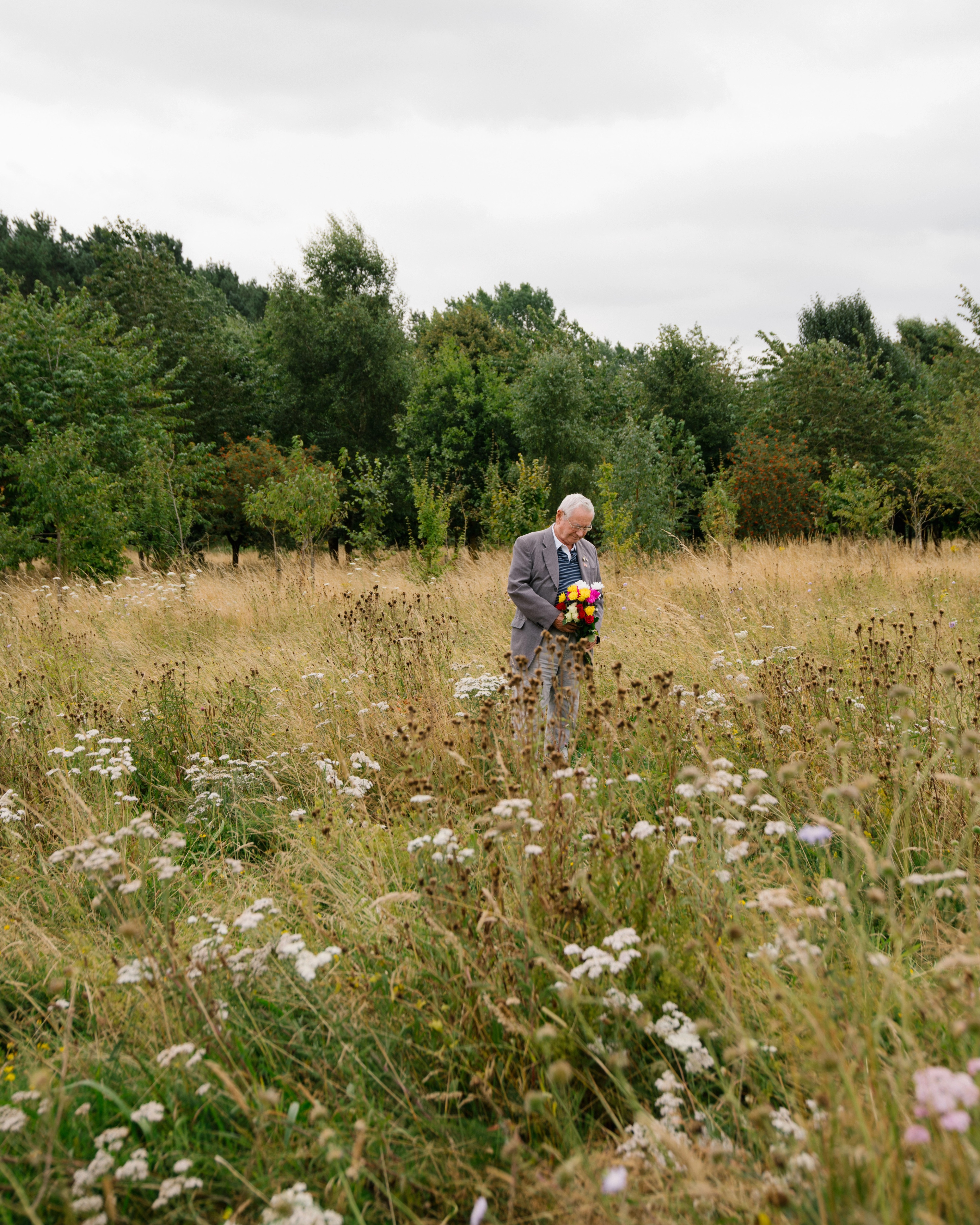 Pete lays flowers above his wife's ashes and memorial tree