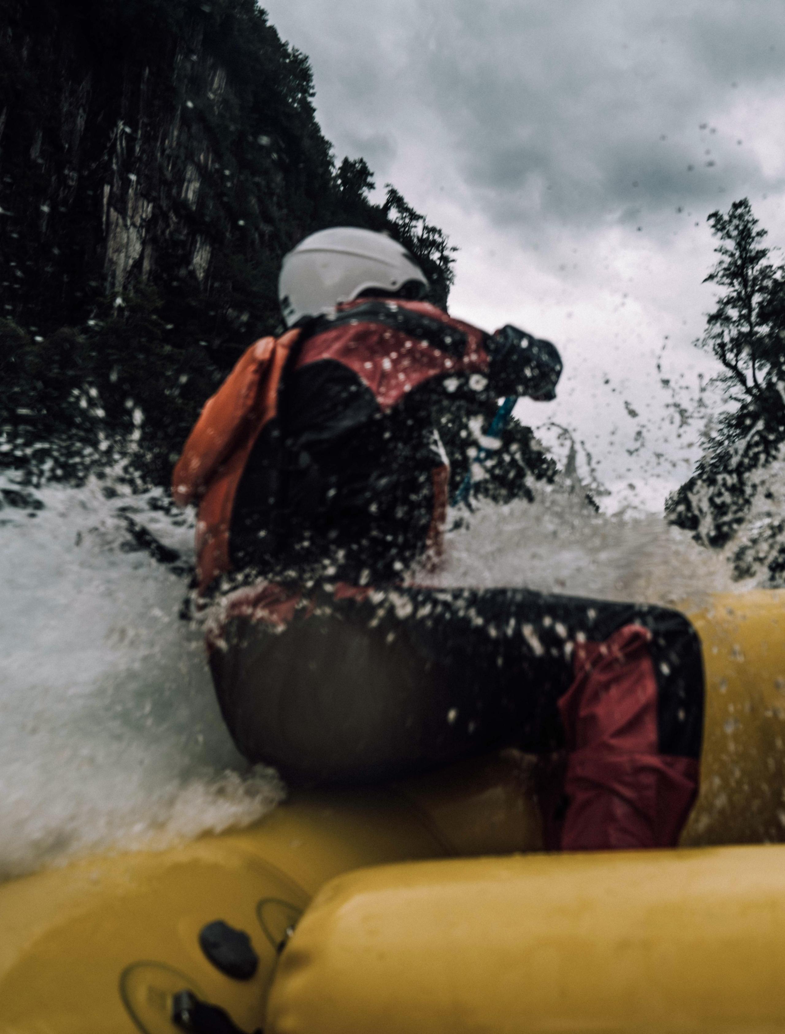 POV of people whitewater rafting with water spraying