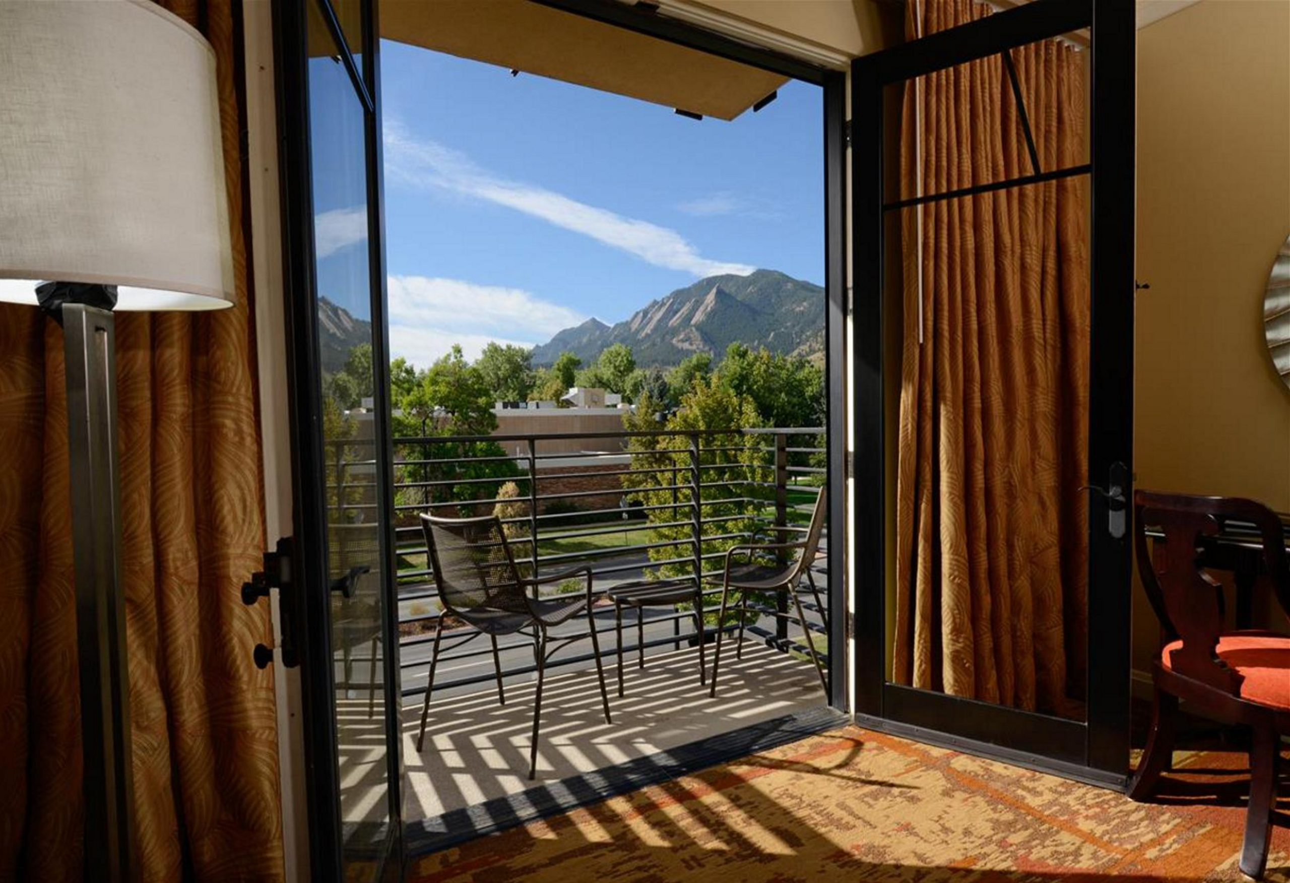 View from inside hotel room looking out to balcony with mountains in background