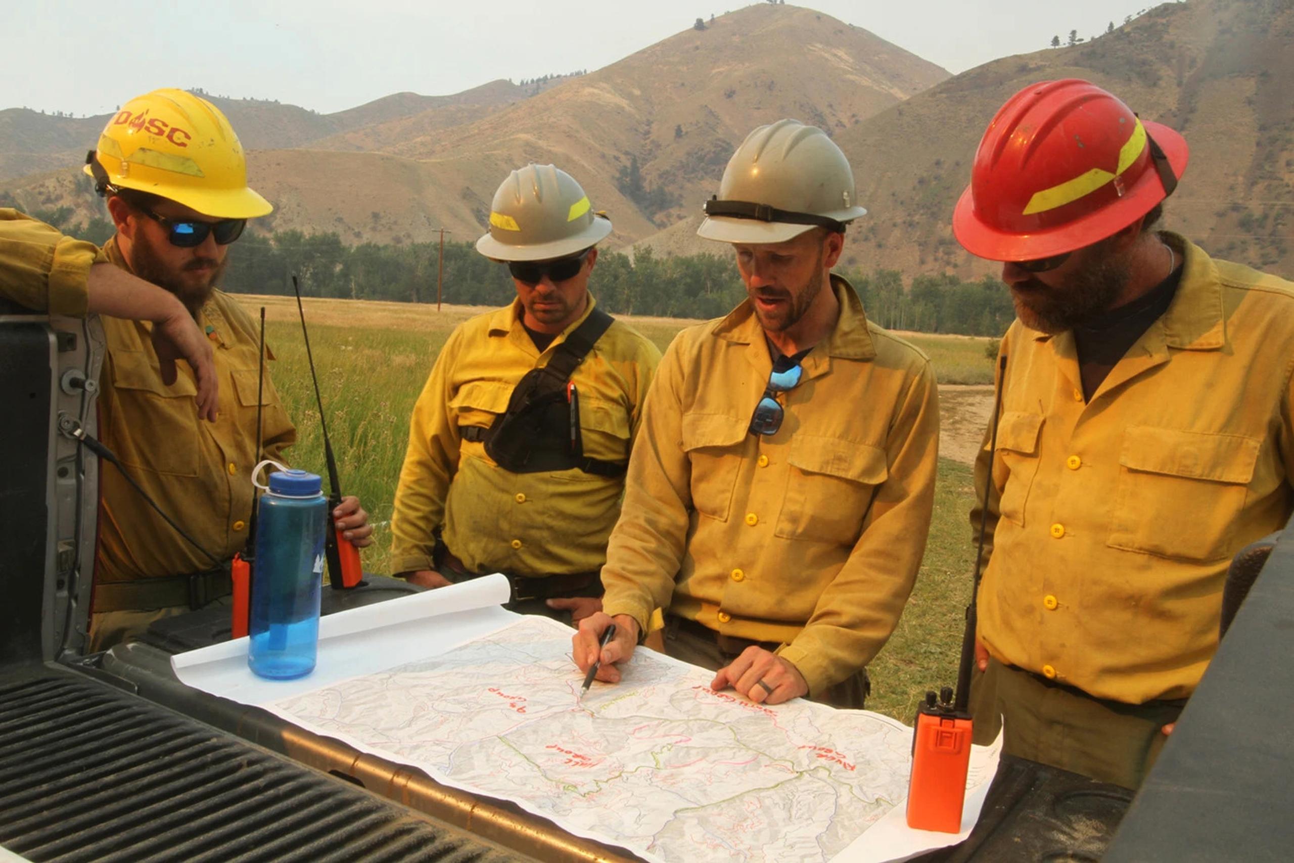 Smokejumpers analyzing map in the back of truck