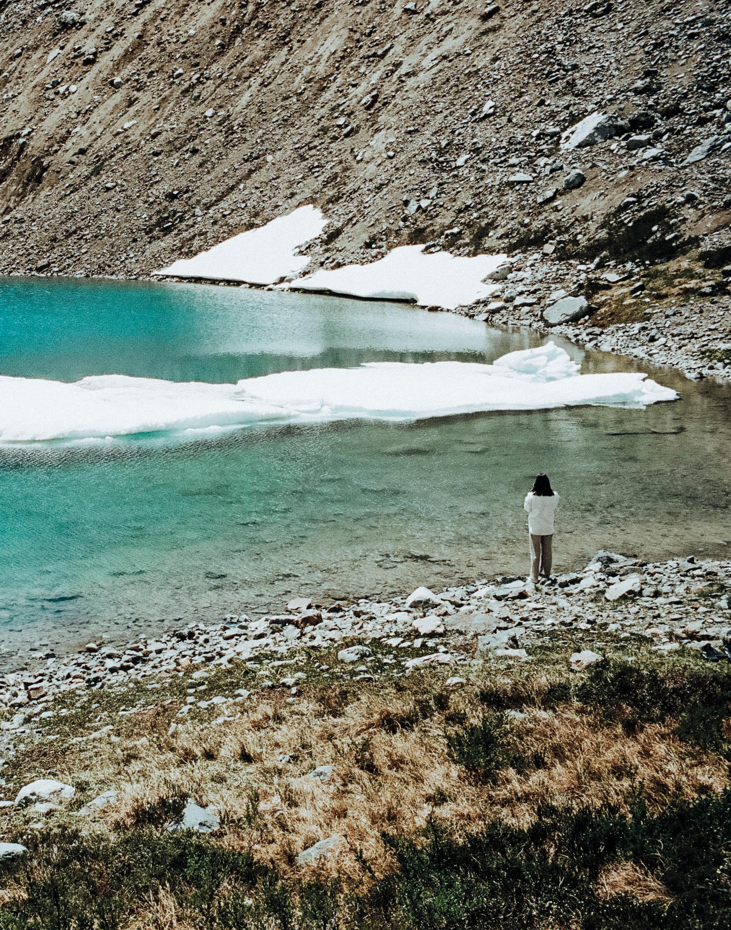 Woman standing on edge of icy lake in Patagonia
