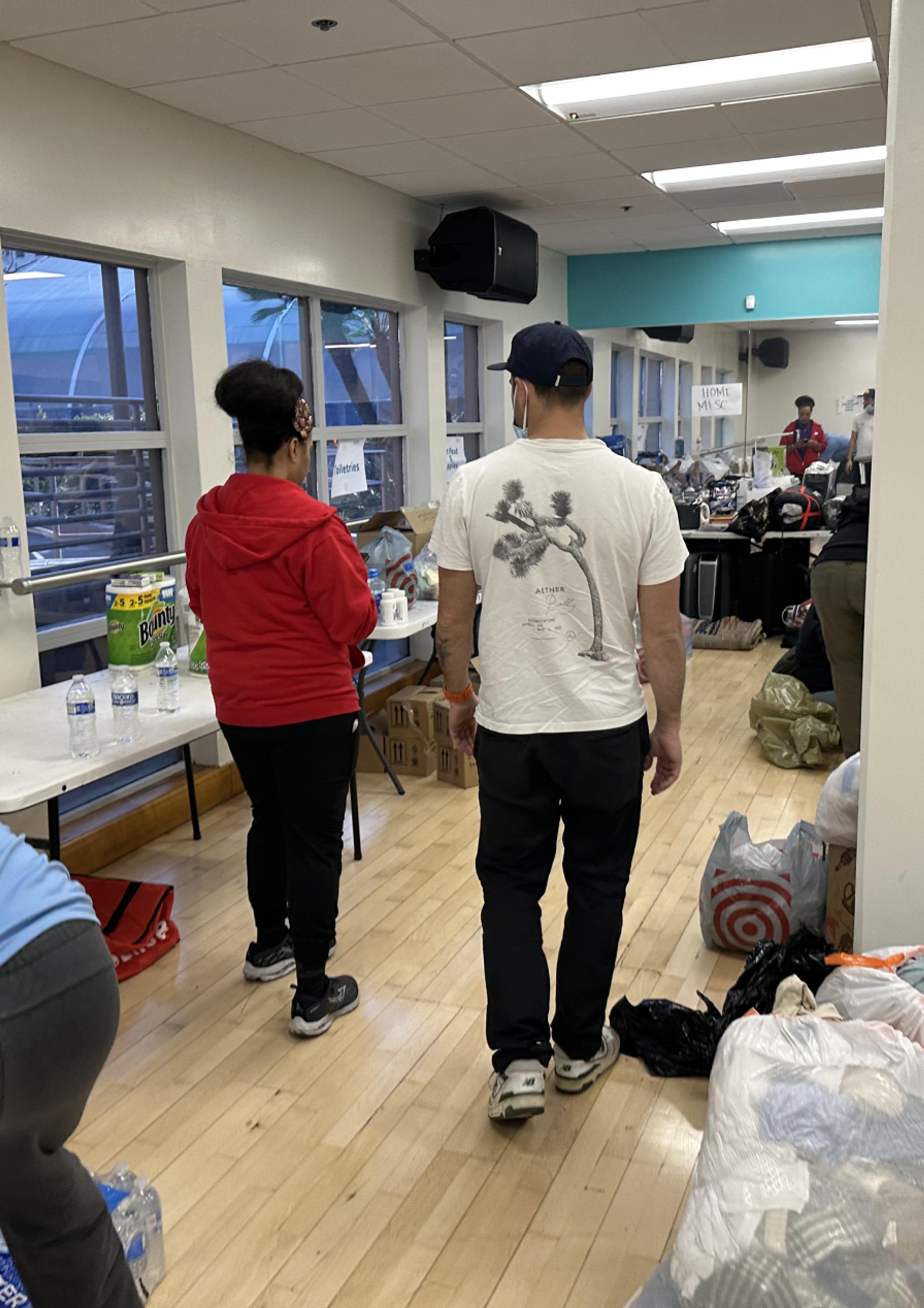 Man and woman walking in YMCA helping organize donations