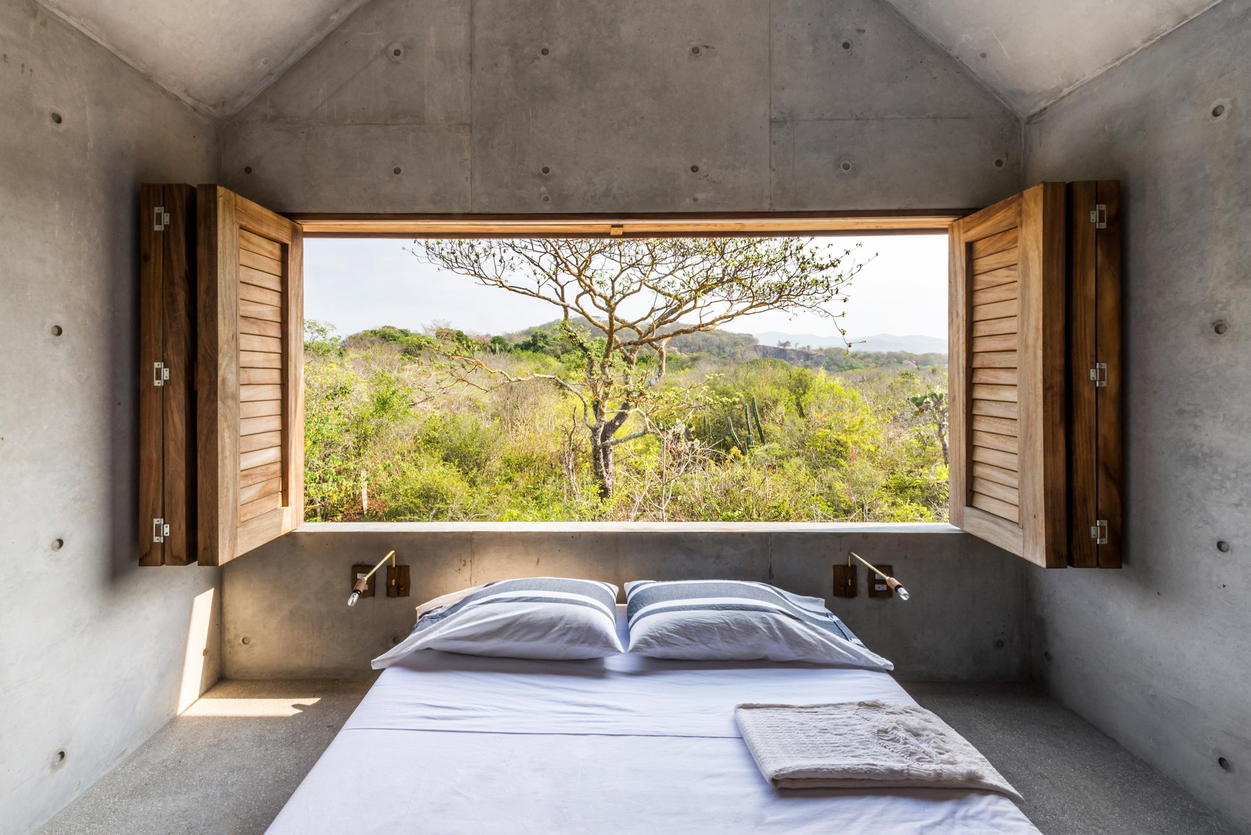 bed with open window revealing nature view
