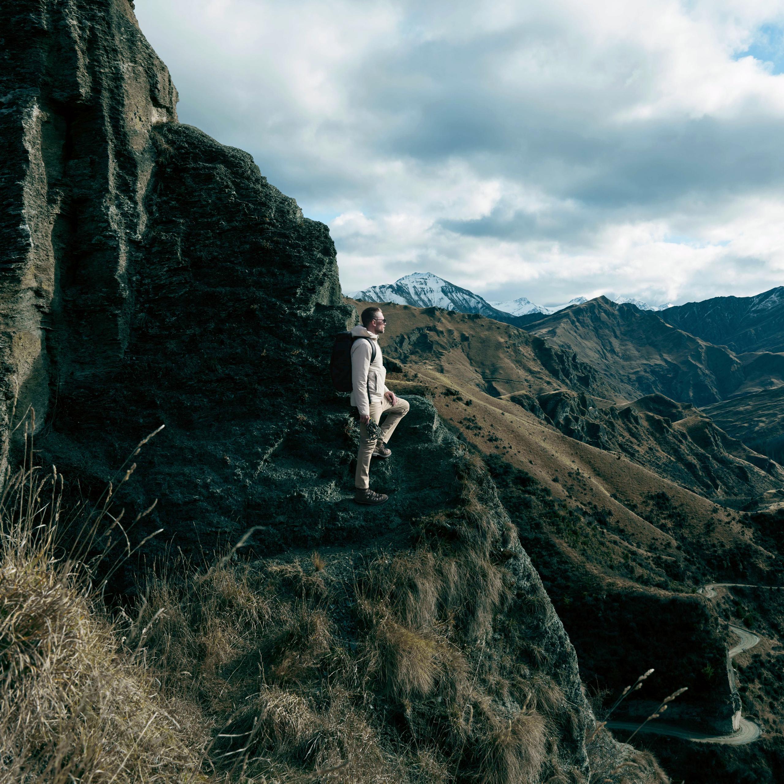 Woman stepping up to roof of white Defender truck in Iceland landscape