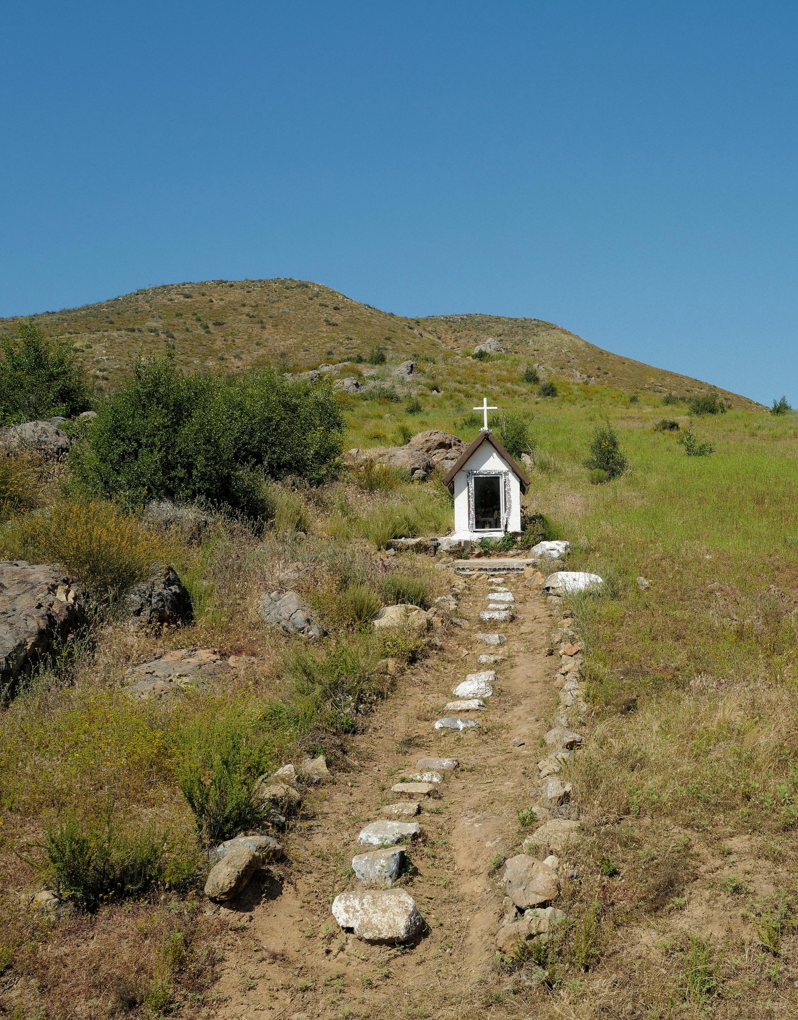 Small church in rural Baja California landscape with dirt and stone path
