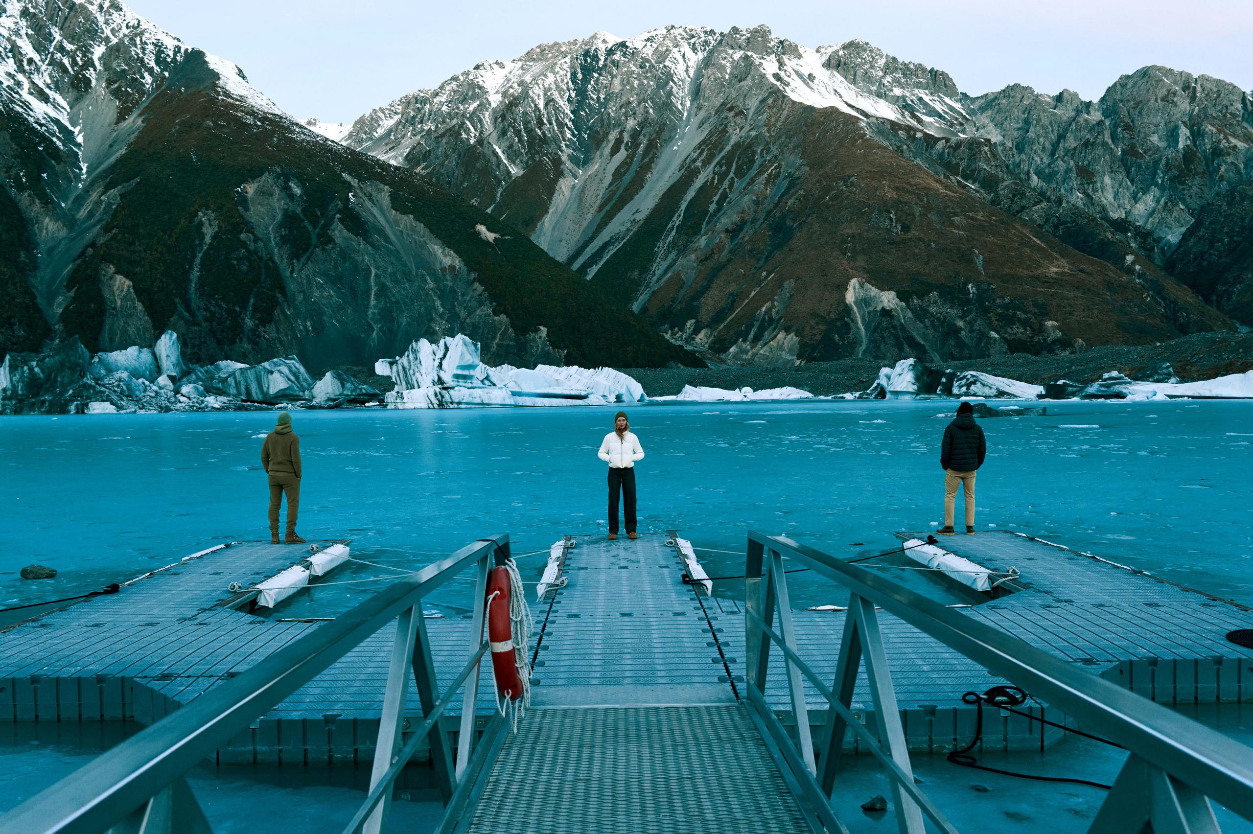 Three fit models wearing Aether clothing on a dock.