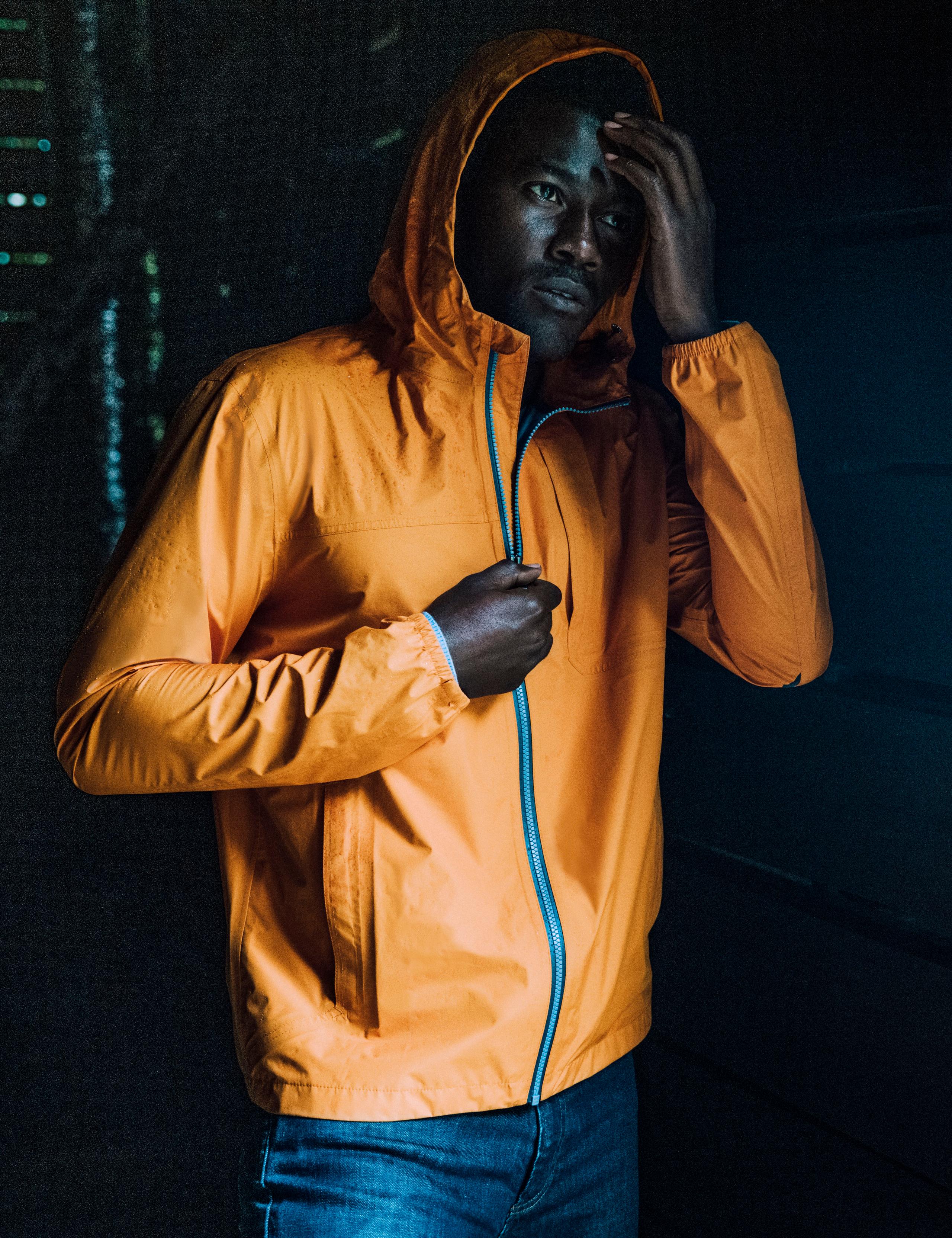 Remy peering into the distance while adorned with the Midas Orange Storm All-Weather Jacket