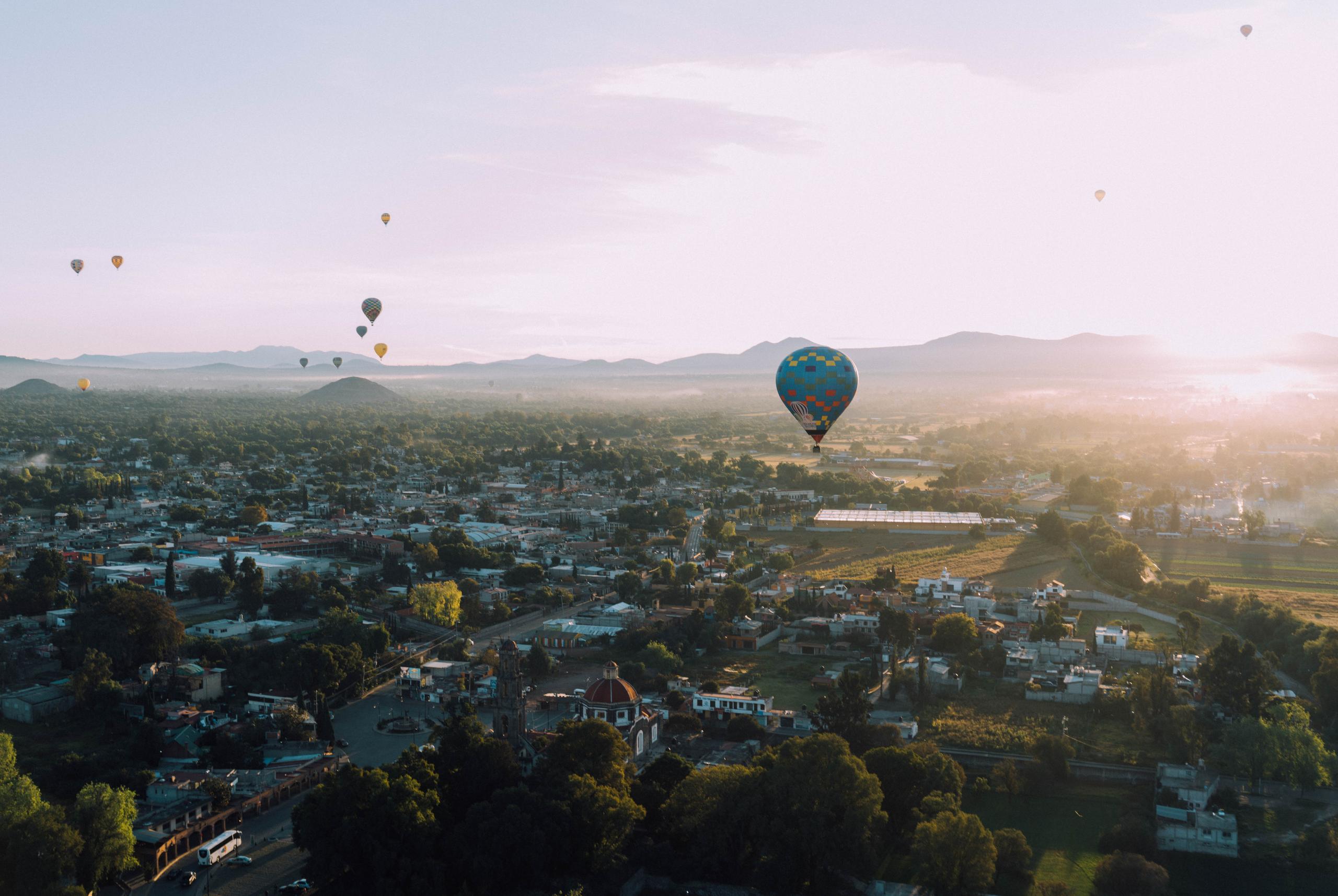 hot air balloons hovering over city