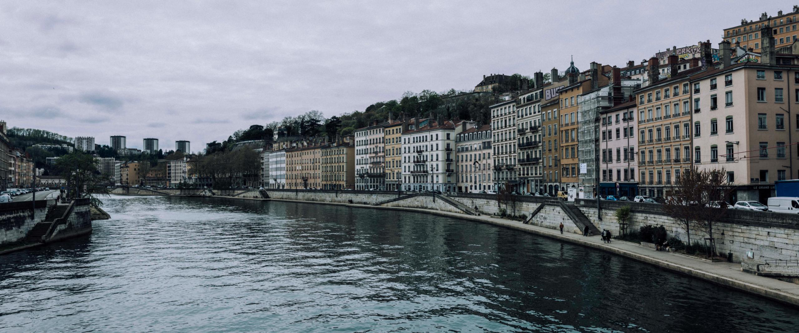 River running through the city of Lyon, France on a cloudy day