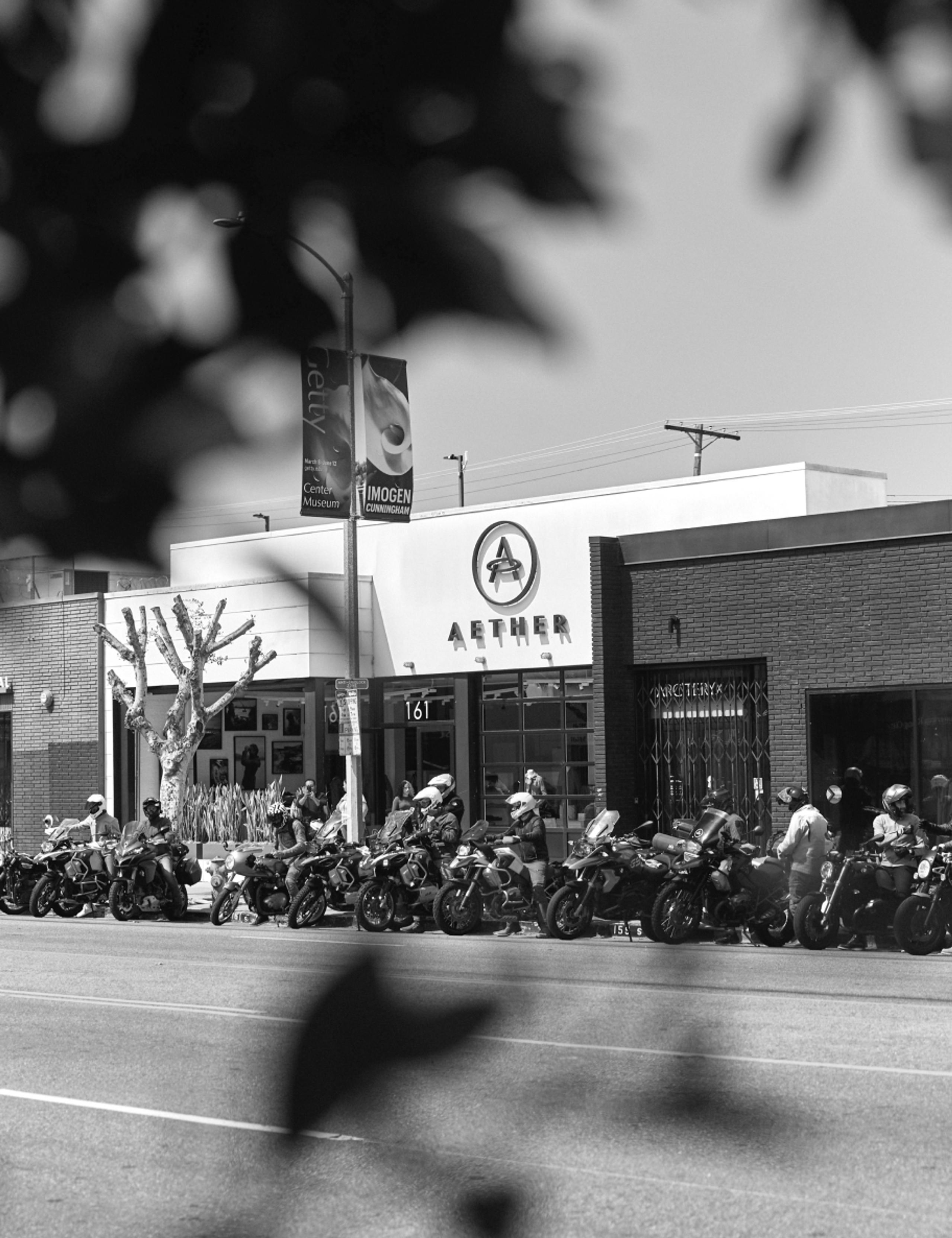 Black and white photo of motorcyclists lined up in front of AETHER store in Los Angeles