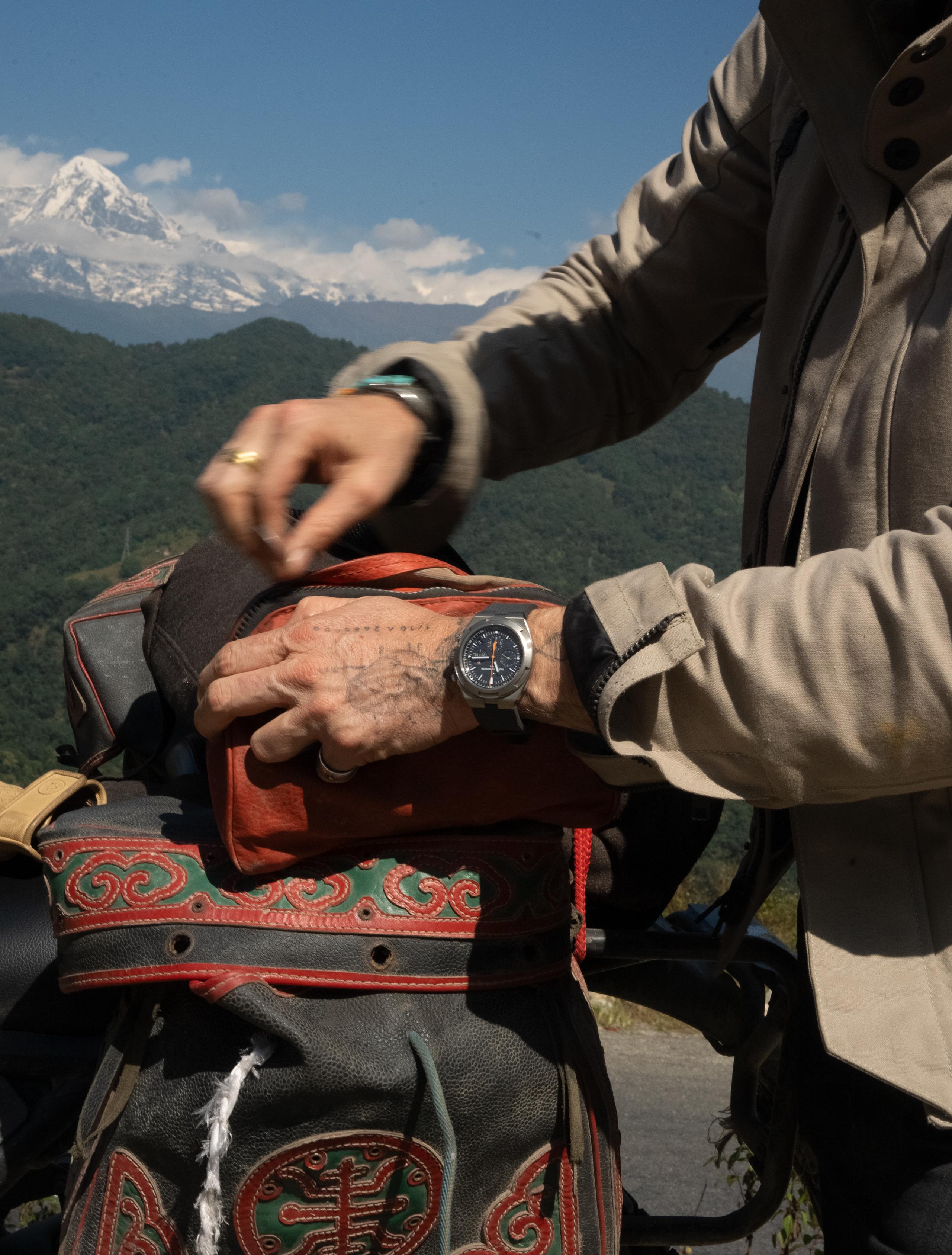 Crop of man unzipping Nepalese backpack on top of motorcycle