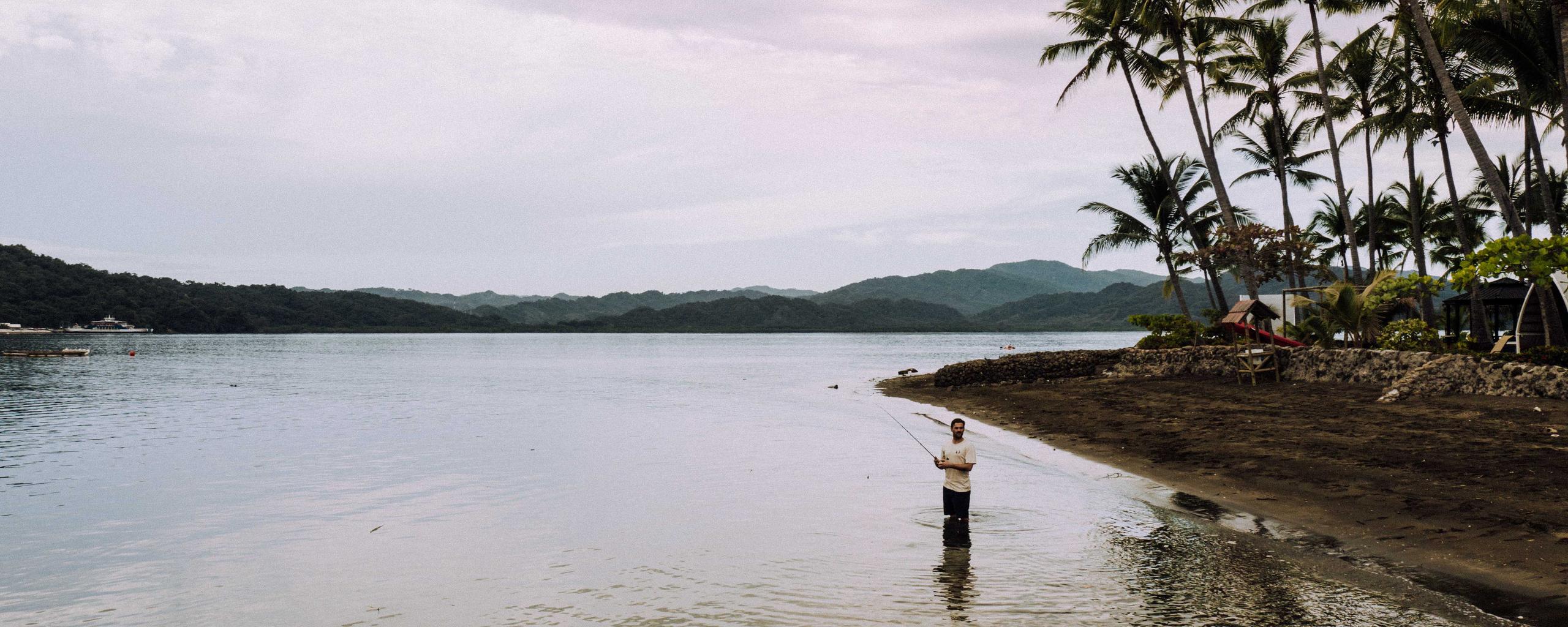 Man standing in Costa Rica lake fishing 