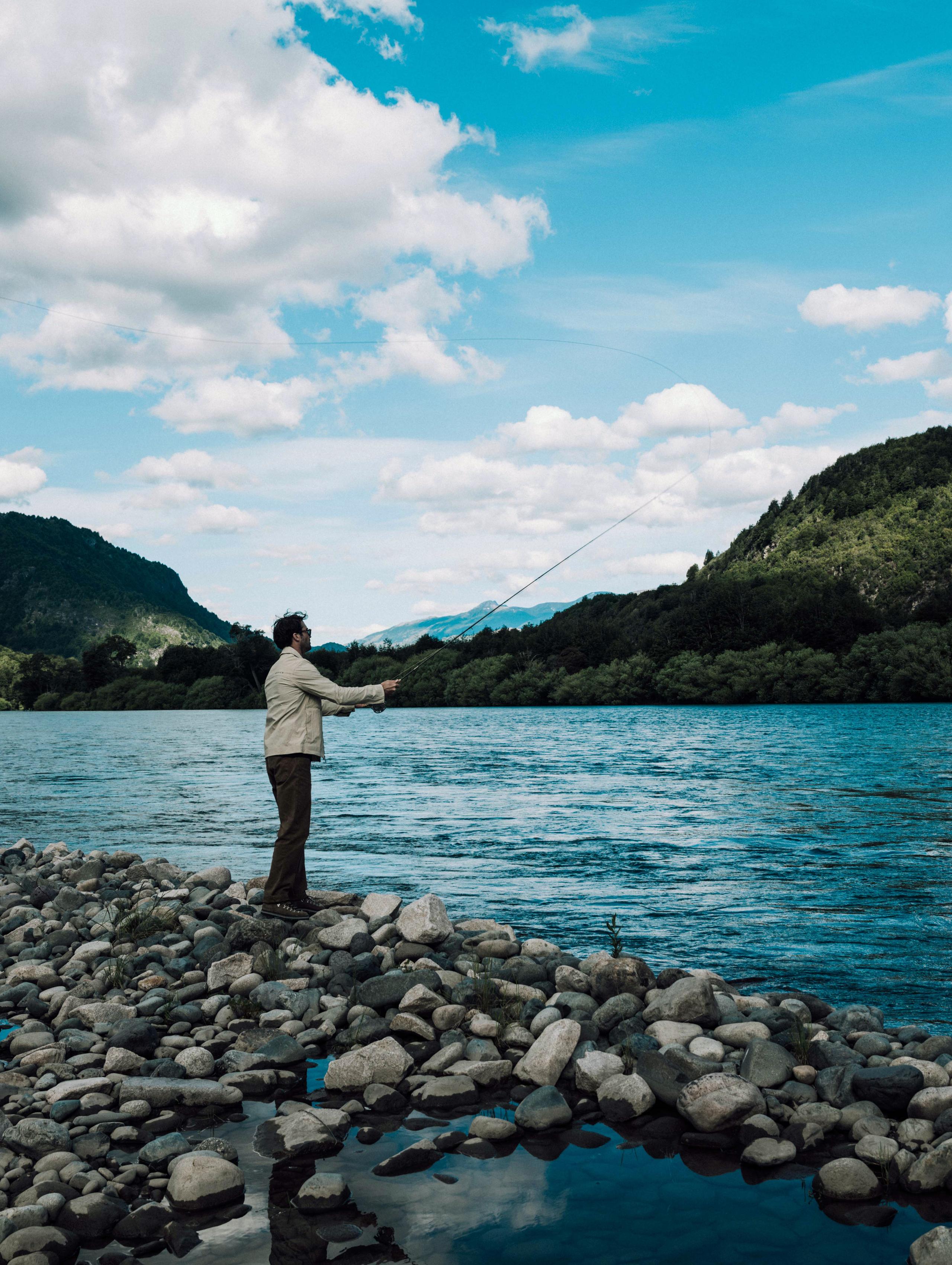 Man fly fishing on river's edge in Patagonia