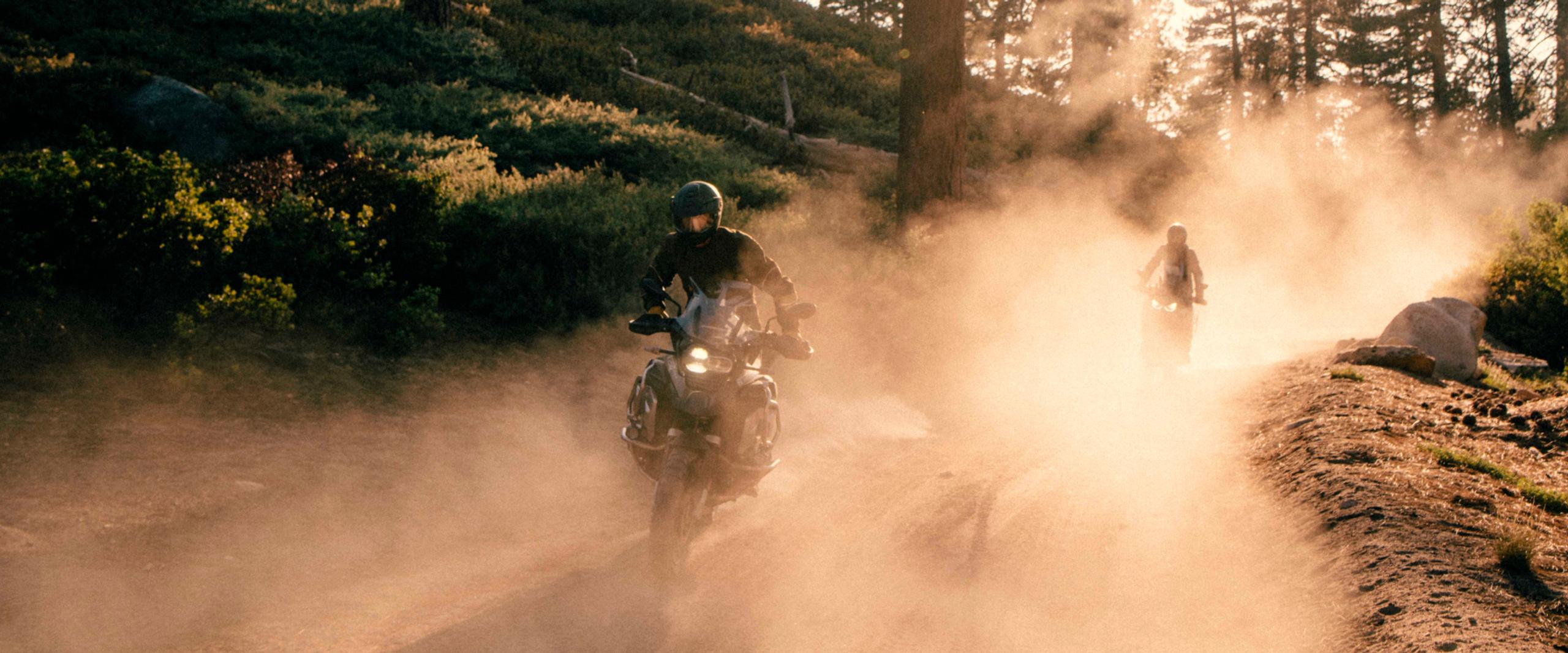 Two motorcyclists kicking up dust clouds riding through Big Bear, California