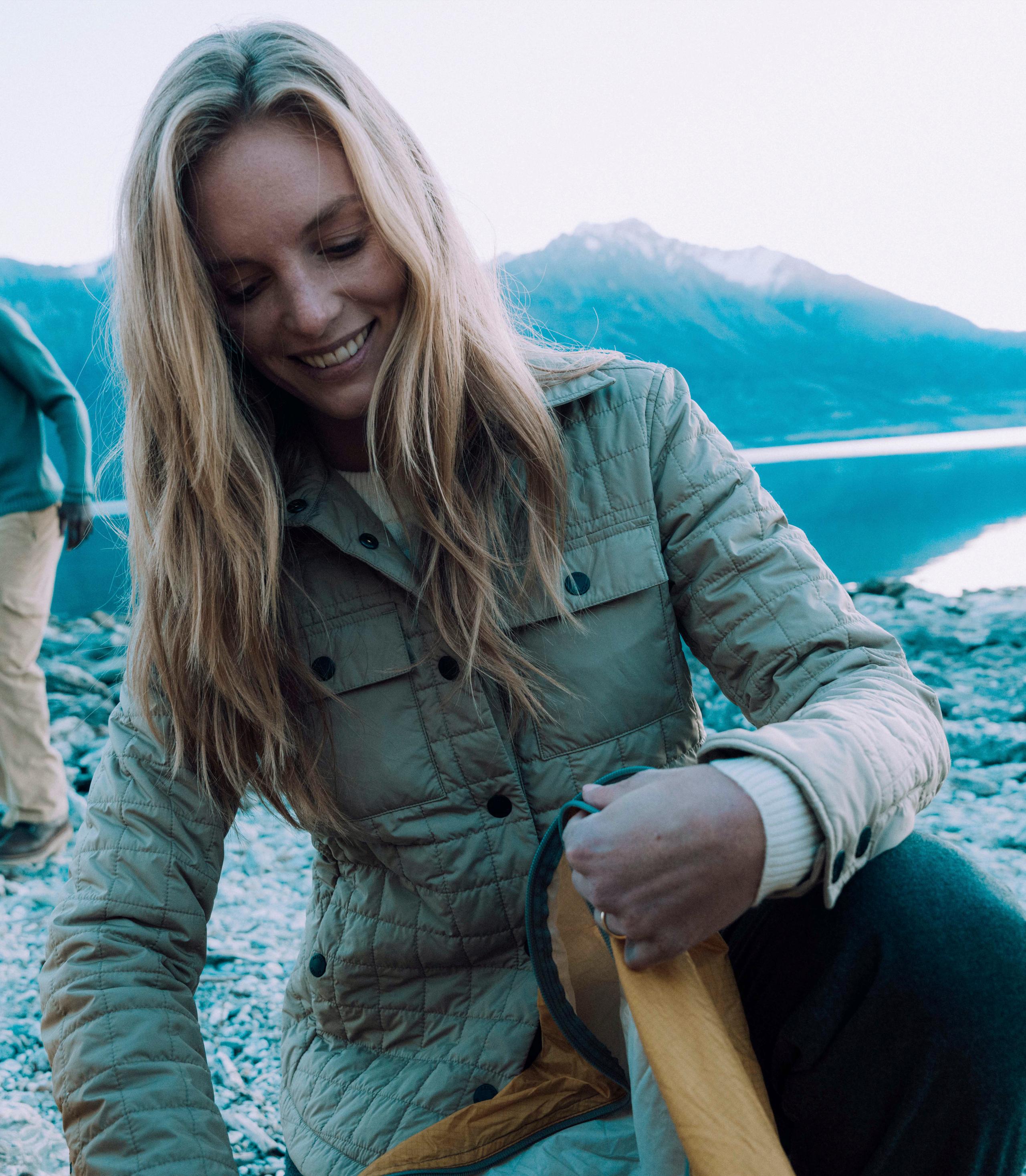 Woman in Bardo Shirt Jacket packing up tent in New Zealand landscape