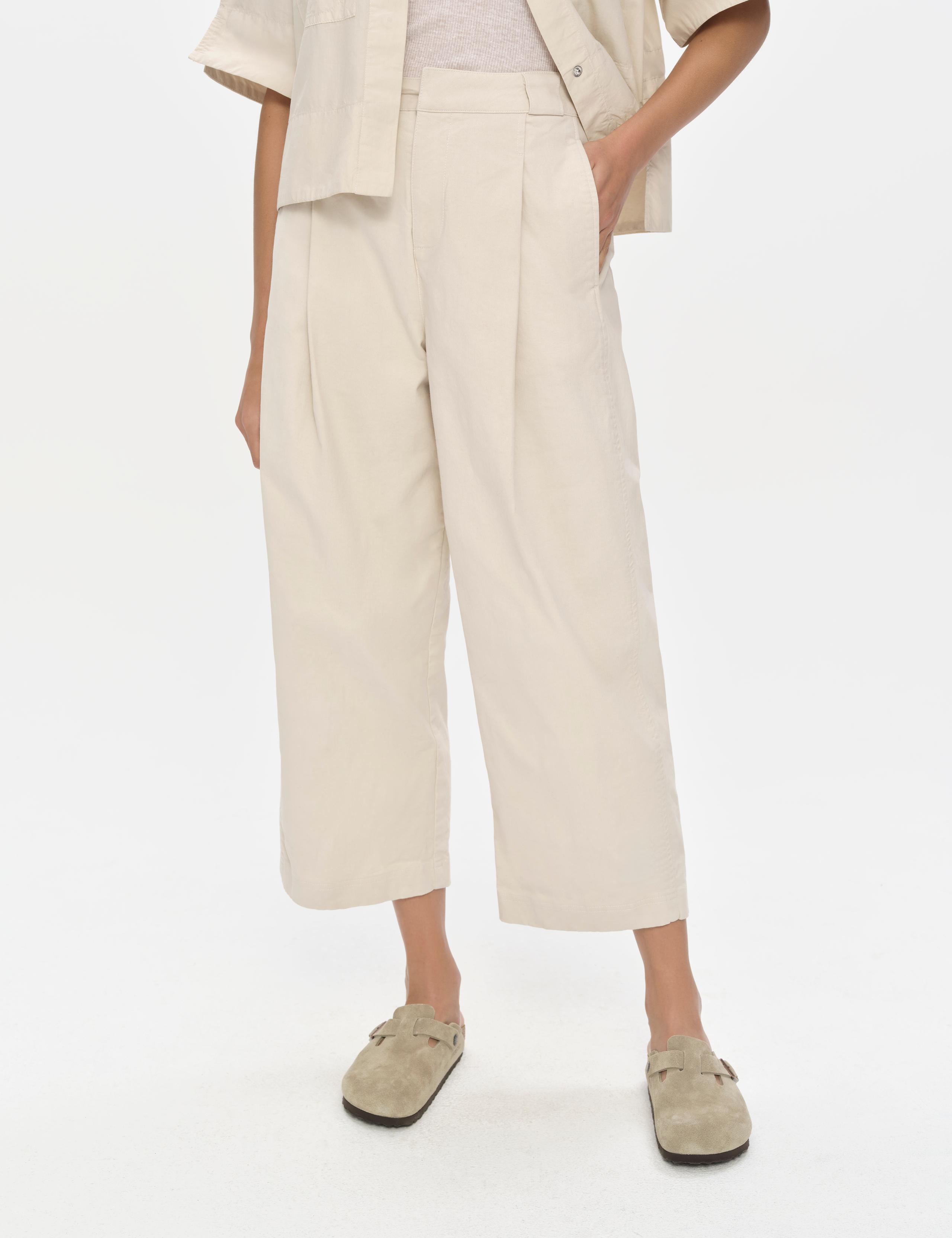 Crop of woman in studio wearing the Dune Pant in Bone