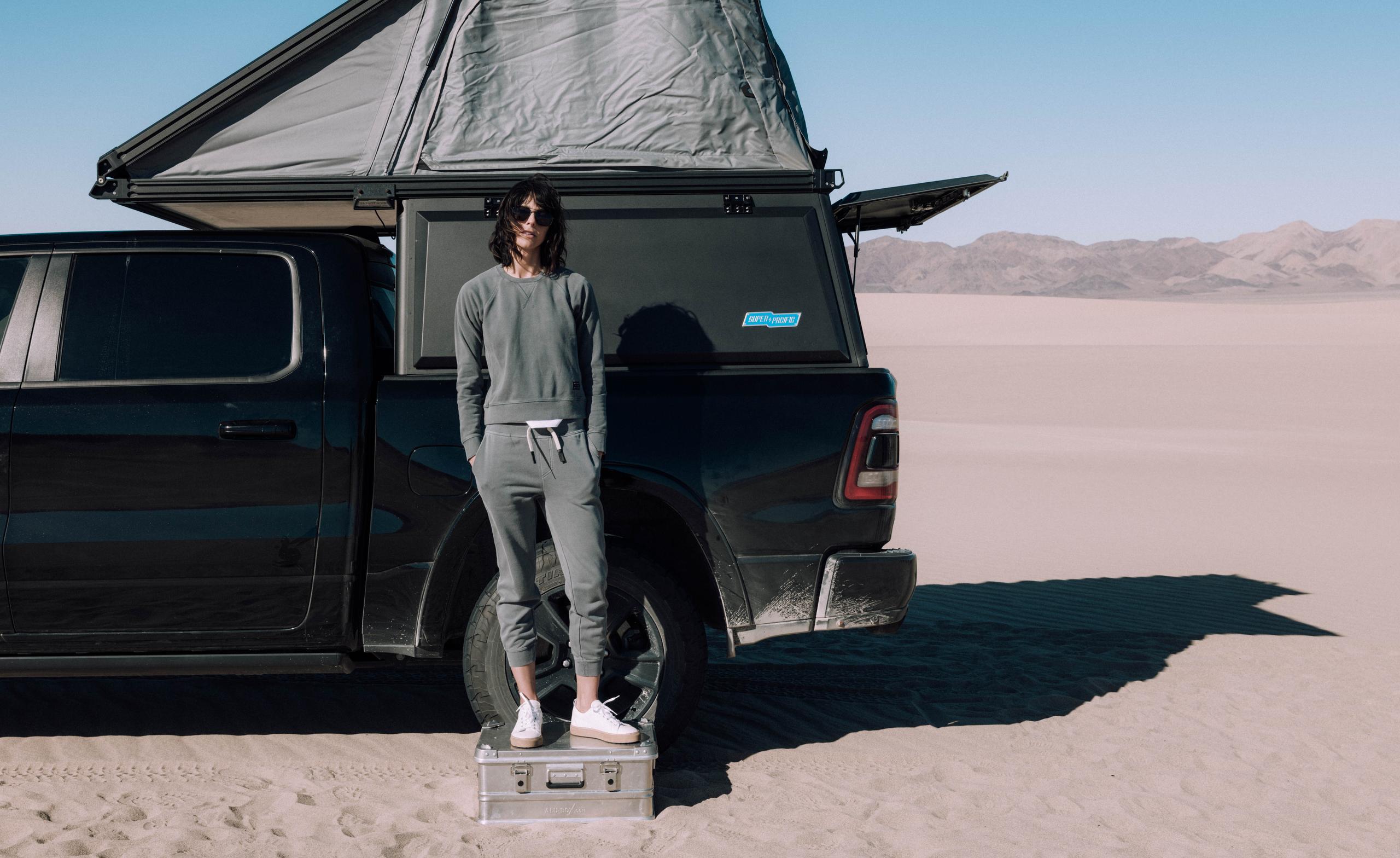 A girl in Solstice Lightweight Raglan Pullover standing in front of a camper truck.