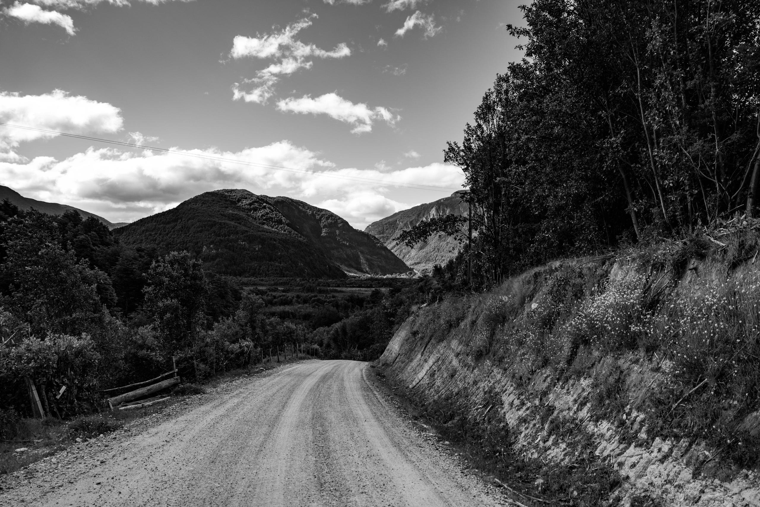 Black and white photo empty dirt road in mountains of Patagonia