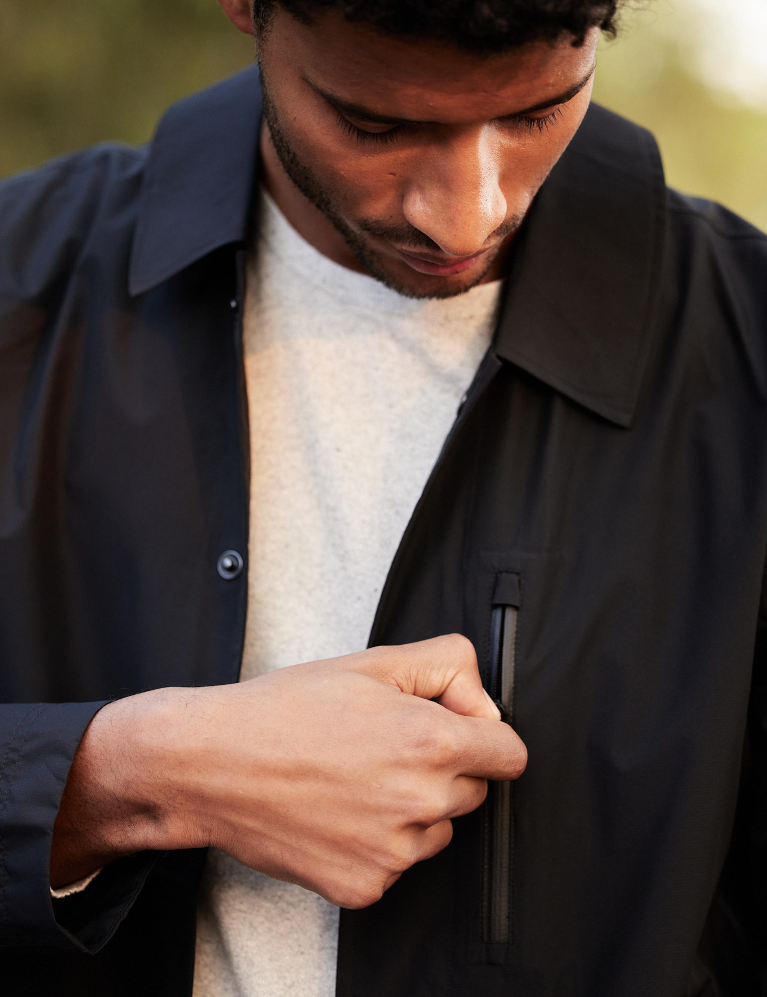 Man wearing Tower Gore-Tex Raincoat opening chest zipper