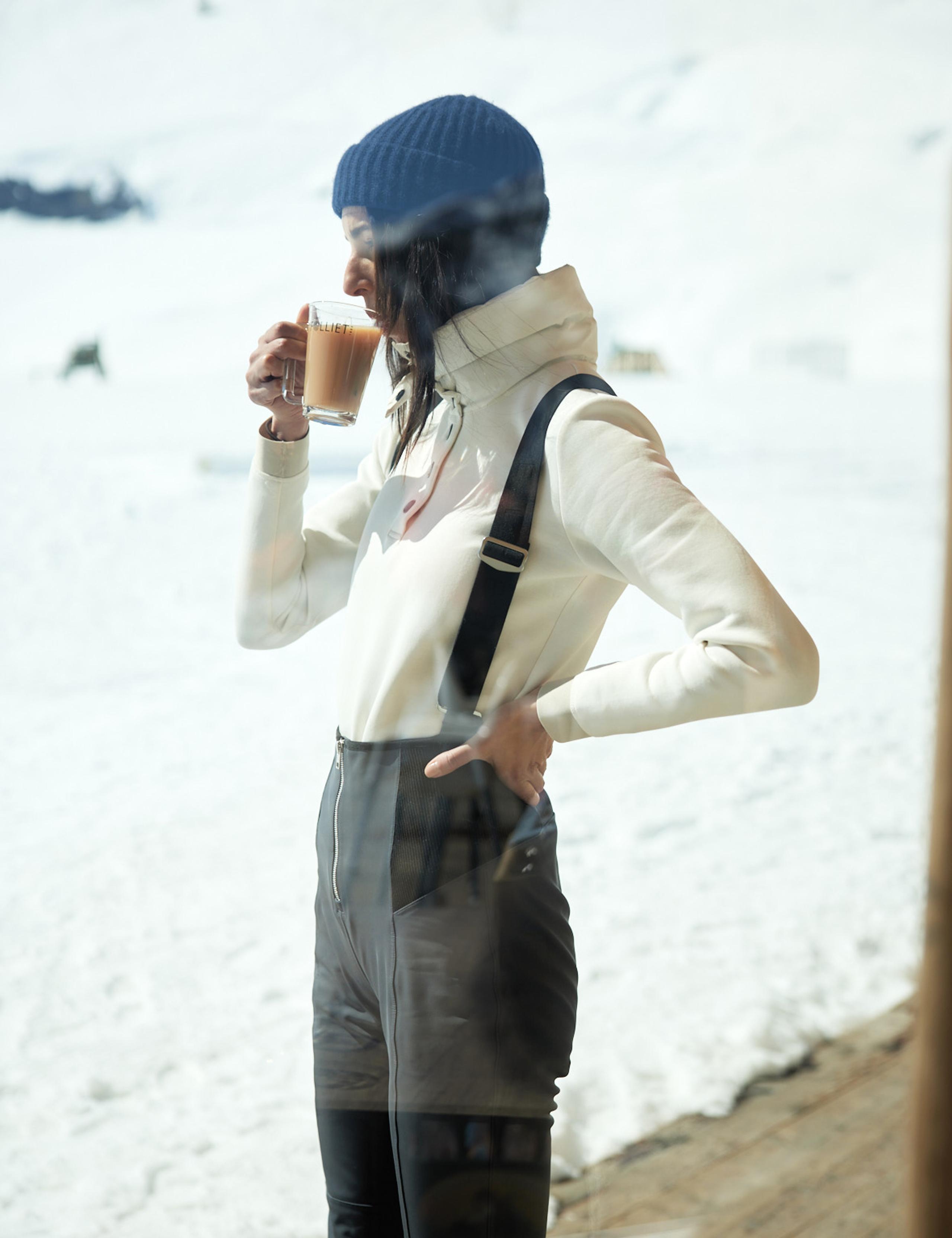 Women in Descent Snow Bib 2.0 sipping coffee 