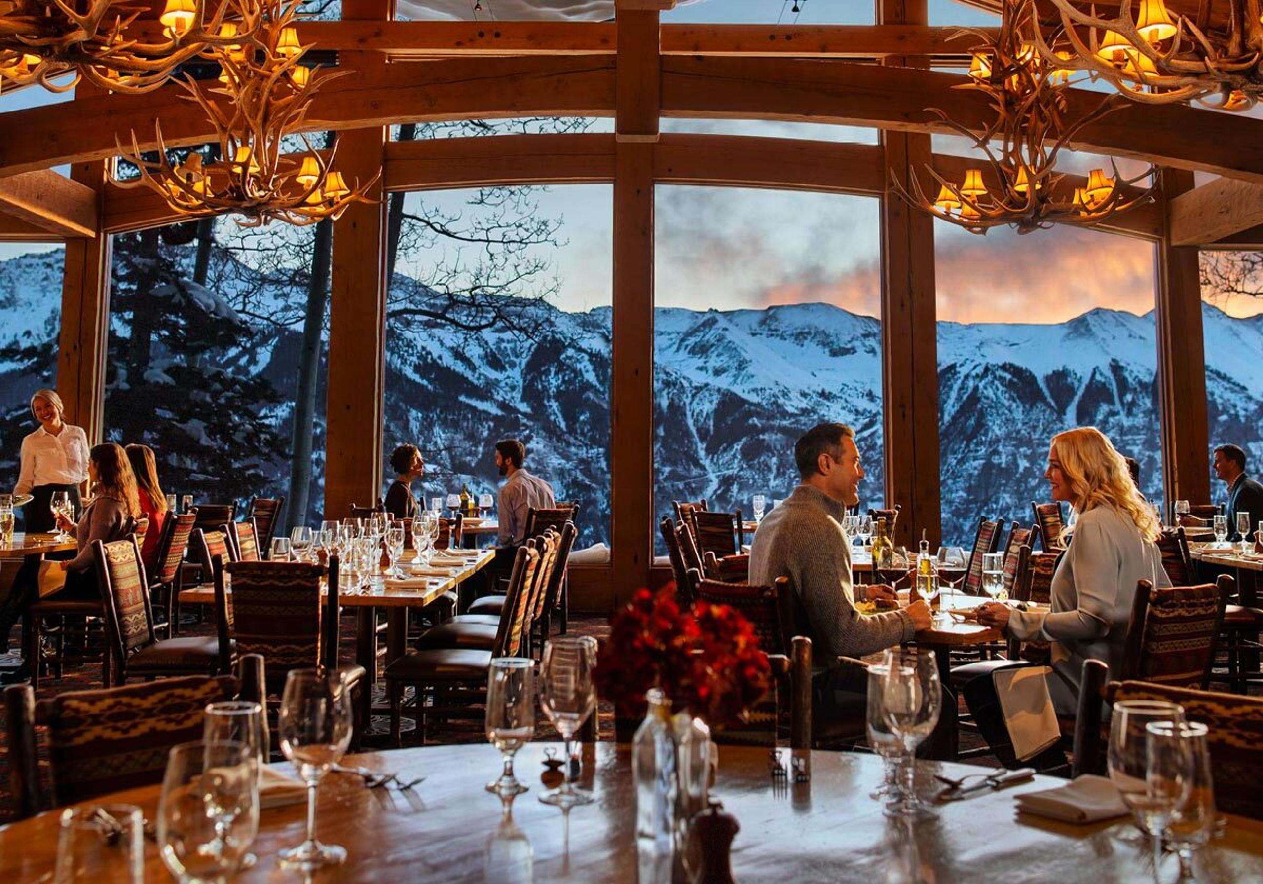 Interior view of people dining in Allred's restaurant with mountains viewed in background
