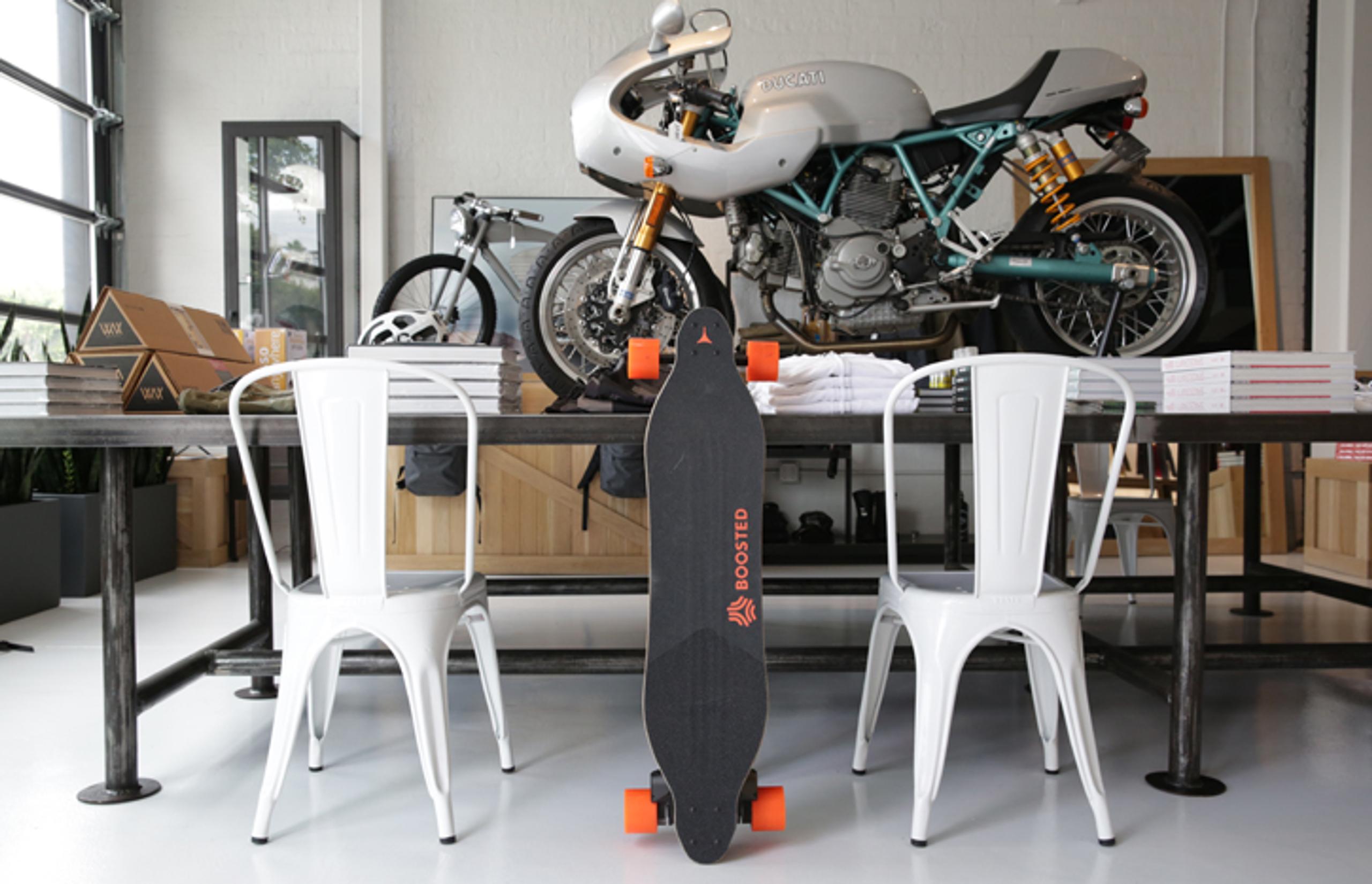 motorcycle and books on a table with skateboard leaning