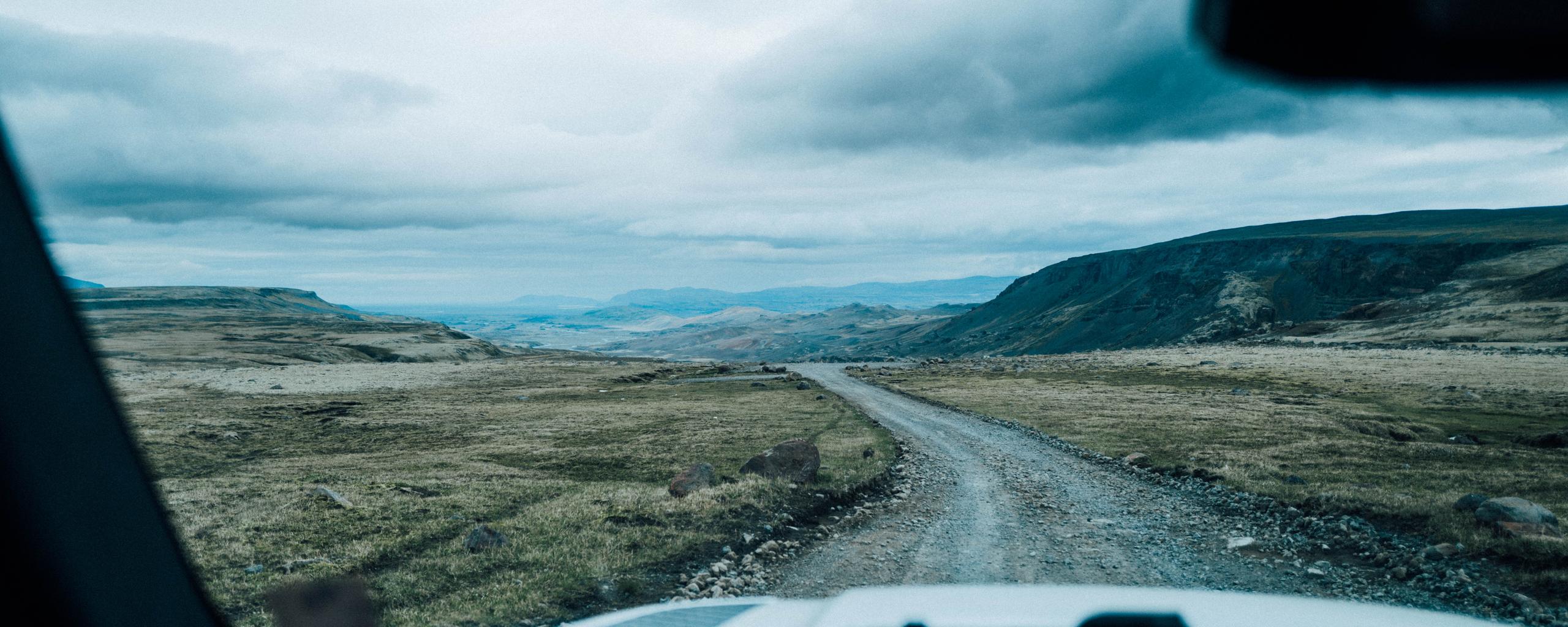 POV view from front windshield looking out at gravel road in Iceland landscape