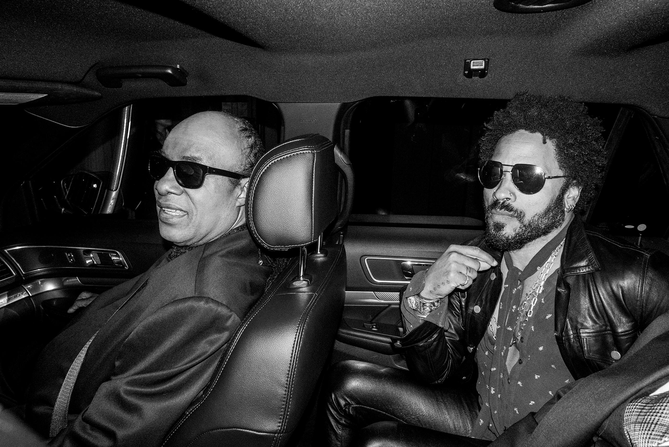 Lenny Kravitz and Stevie Wonder inside a car at night