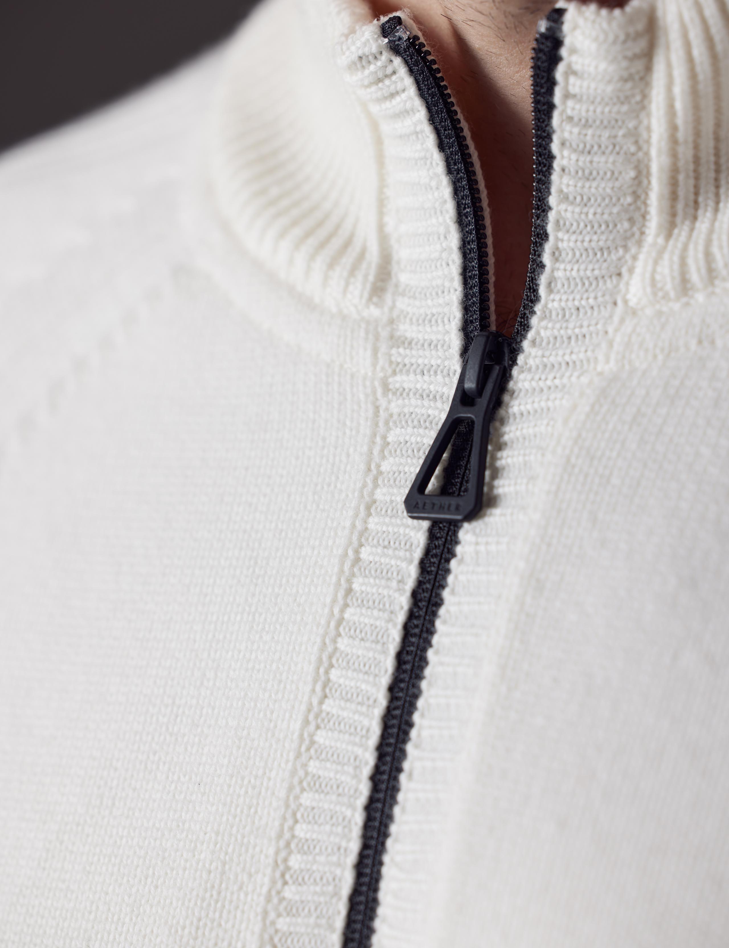 AETHER Defender and Detailed shot of the Riley Full-Zip Sweater.